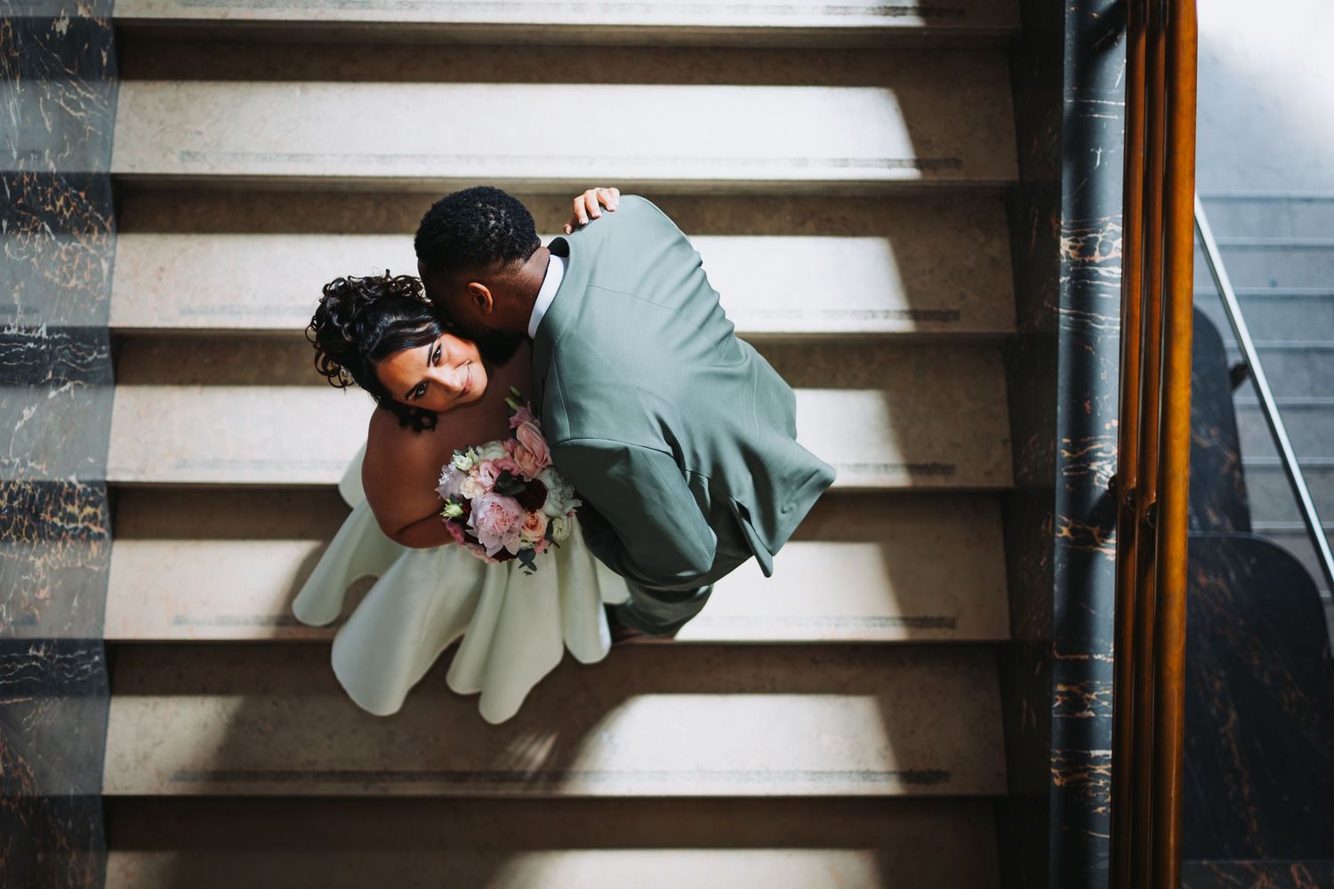 Romantic wedding couple shares intimate moments through a sheer veil in black and white photography.