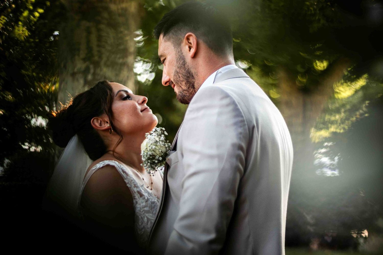 Intimate wedding moment captured in a sunlit garden setting.