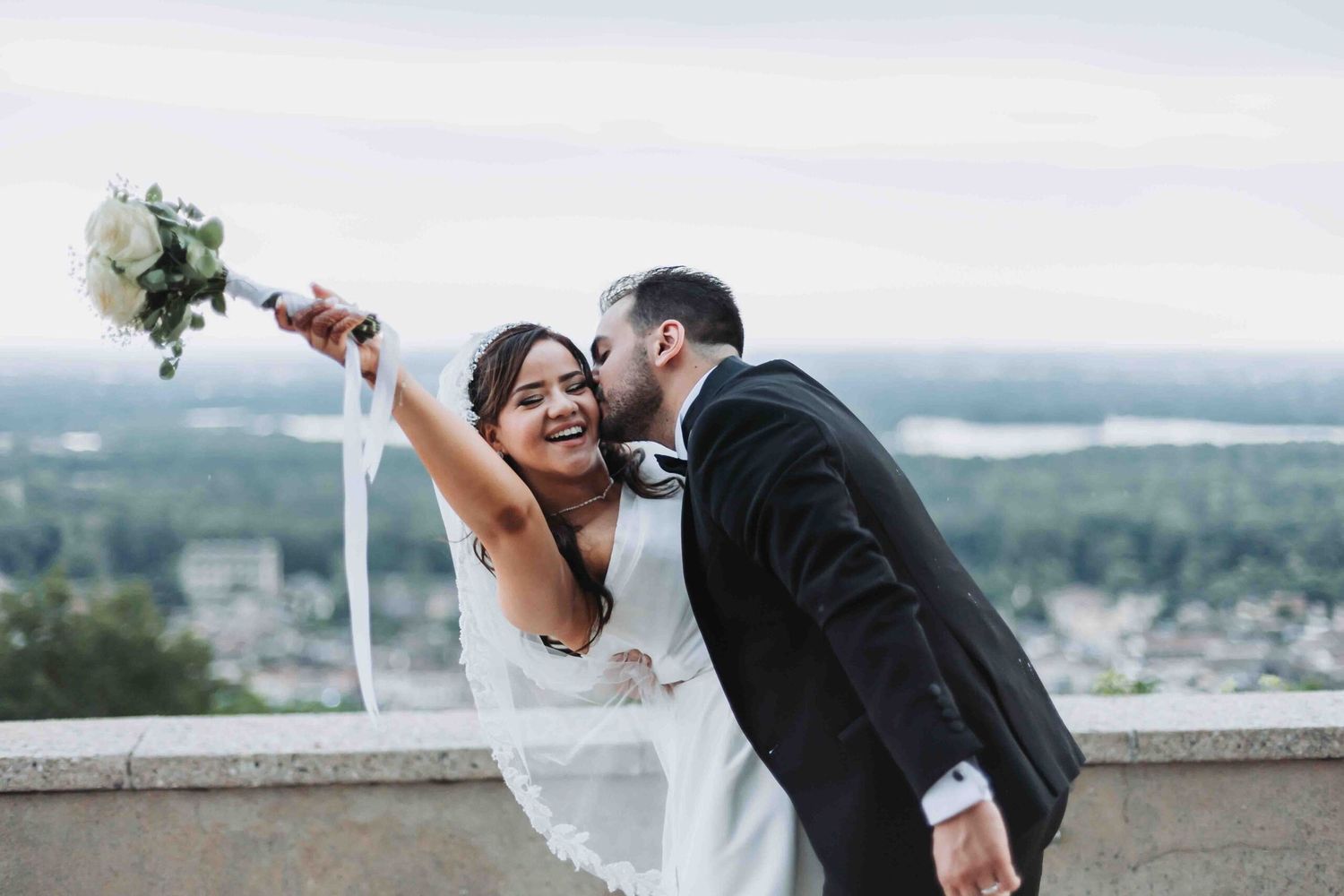 couple de mariés a mariée soulève son bouquet