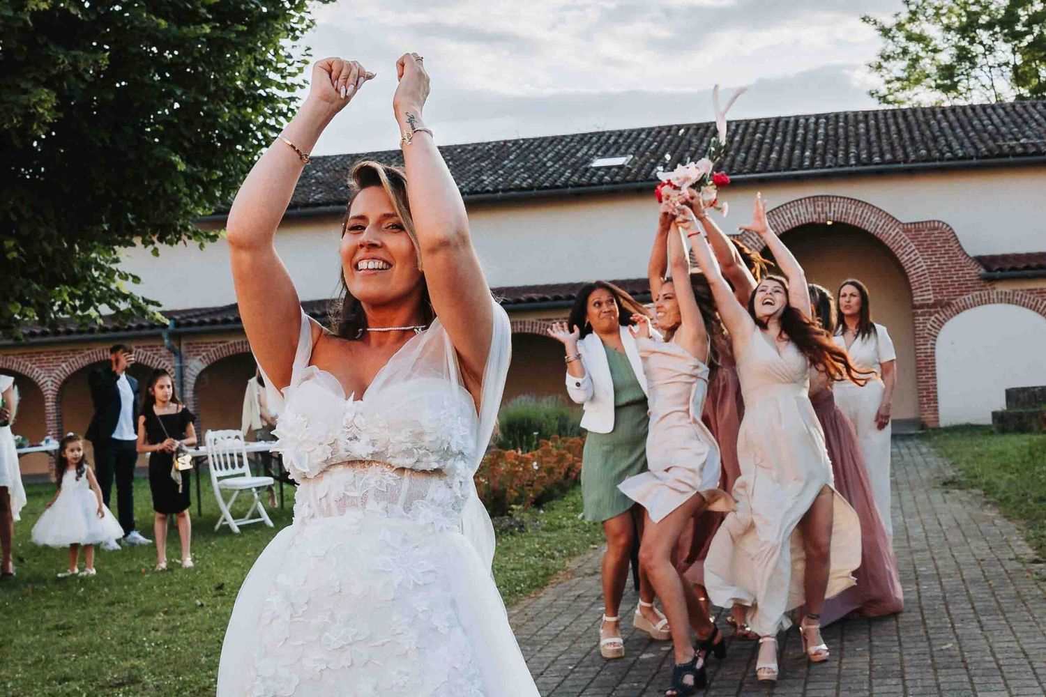 Wedding celebration in a garden courtyard with people dancing and celebrating joyfully.