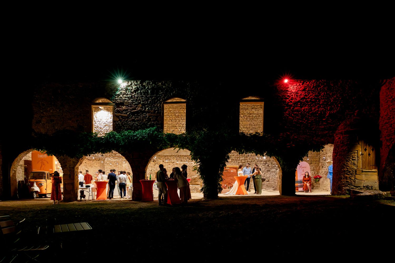 A row of illuminated lanterns and glowing decorations line a dark path during a nighttime festival display.
