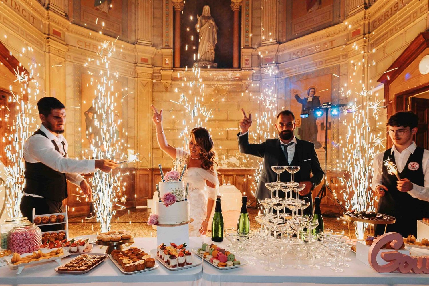 Elegant wedding reception with sparkler fountains and champagne tower display.