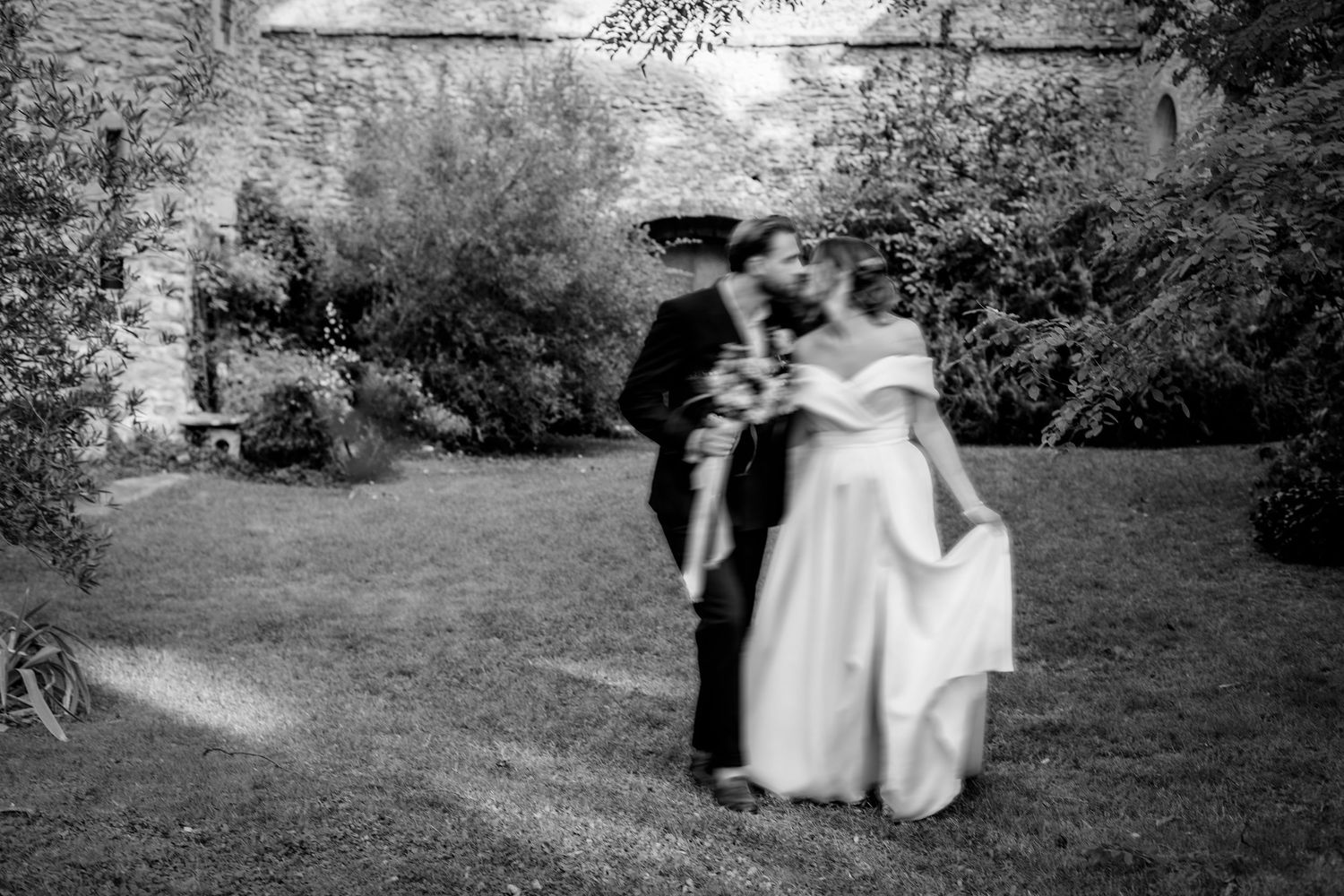 Black and white wedding portraits captured in a serene garden setting.