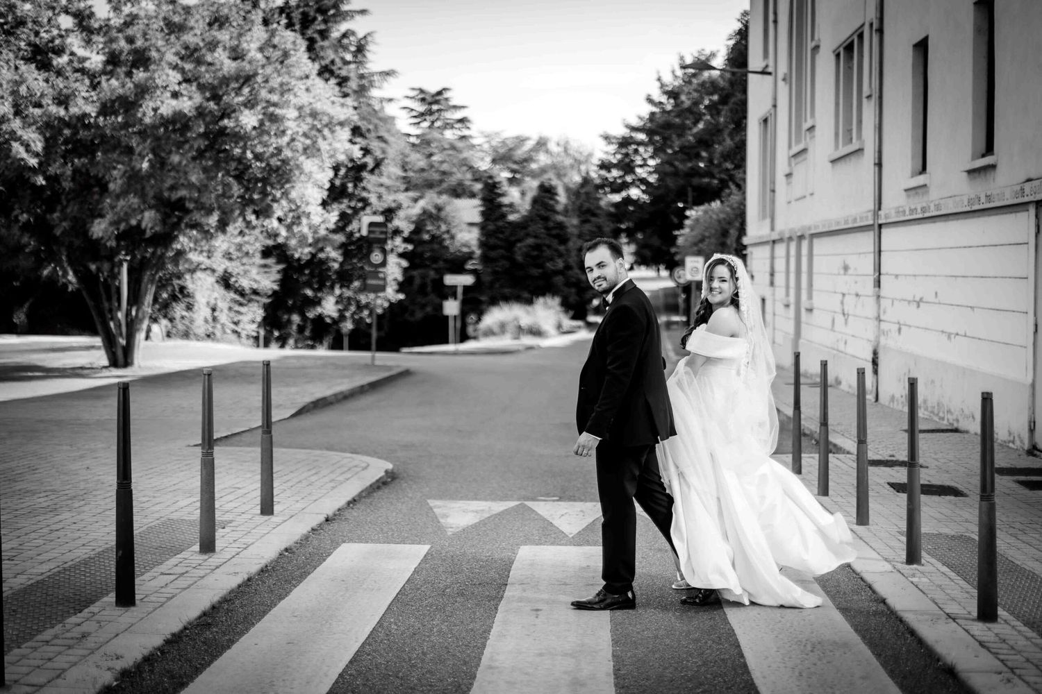 A black and white photo sequence shows a wedding dress flowing in the breeze along a street with bollards.