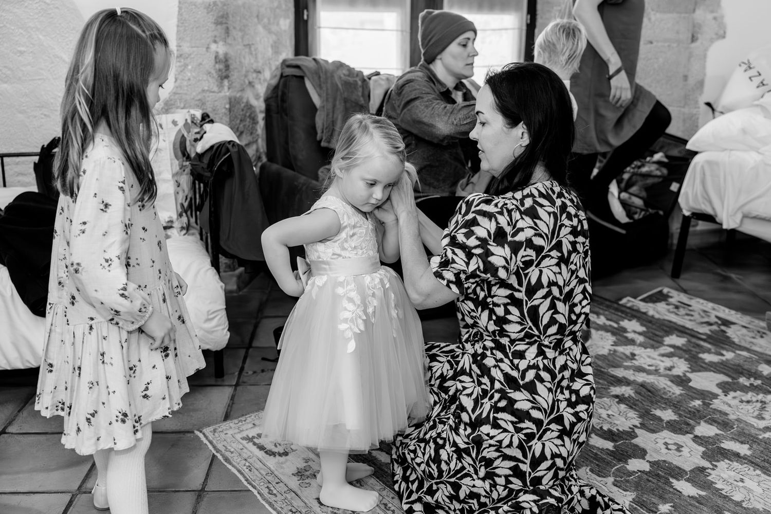 Wedding guests gather around a dance floor during a reception celebration with floral decorations and formal attire.