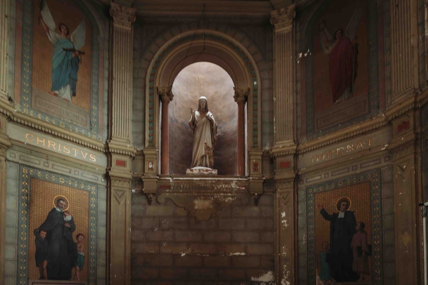 Ornate interior of a historic church with marble columns, arched ceilings, and religious artwork adorning the walls.