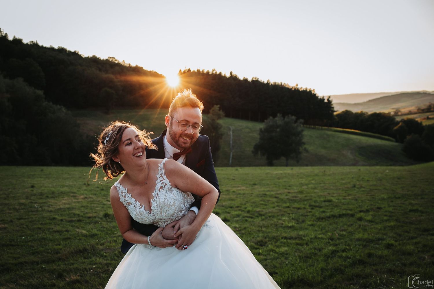 couple de mariés s'enlacent au couché de soleil