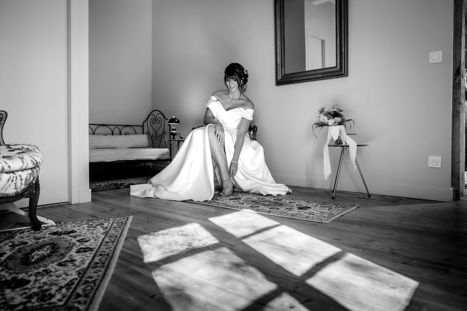 A black and white photo series showing a person in white sitting in various positions on a wooden floor.