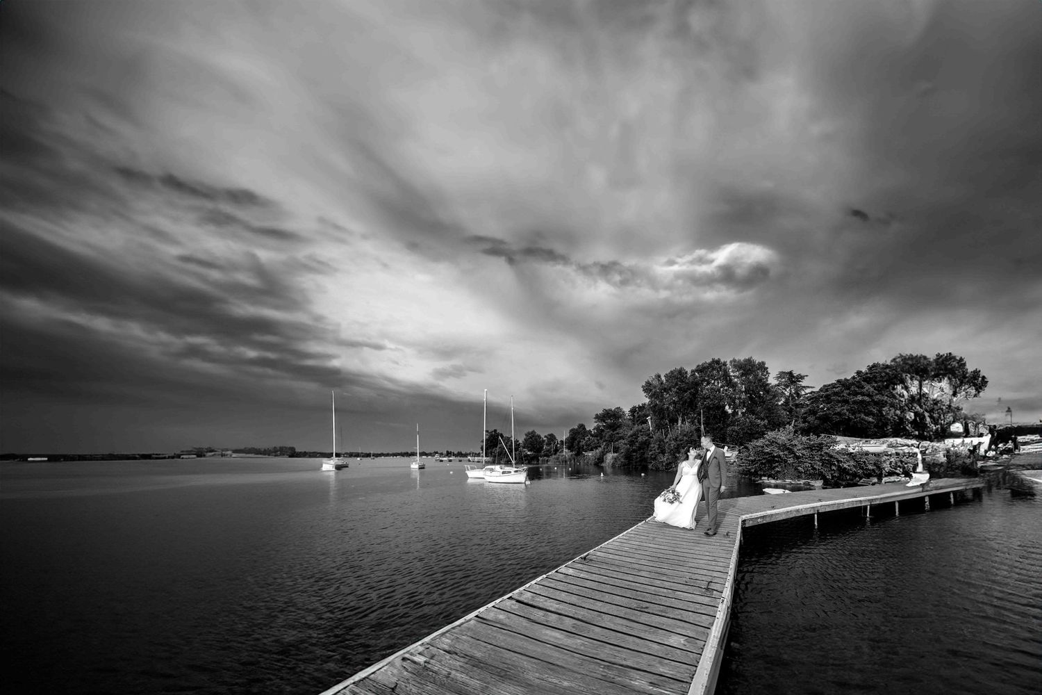 couple de mariés en noir et blanc sur le ponton du grand large meyzieu