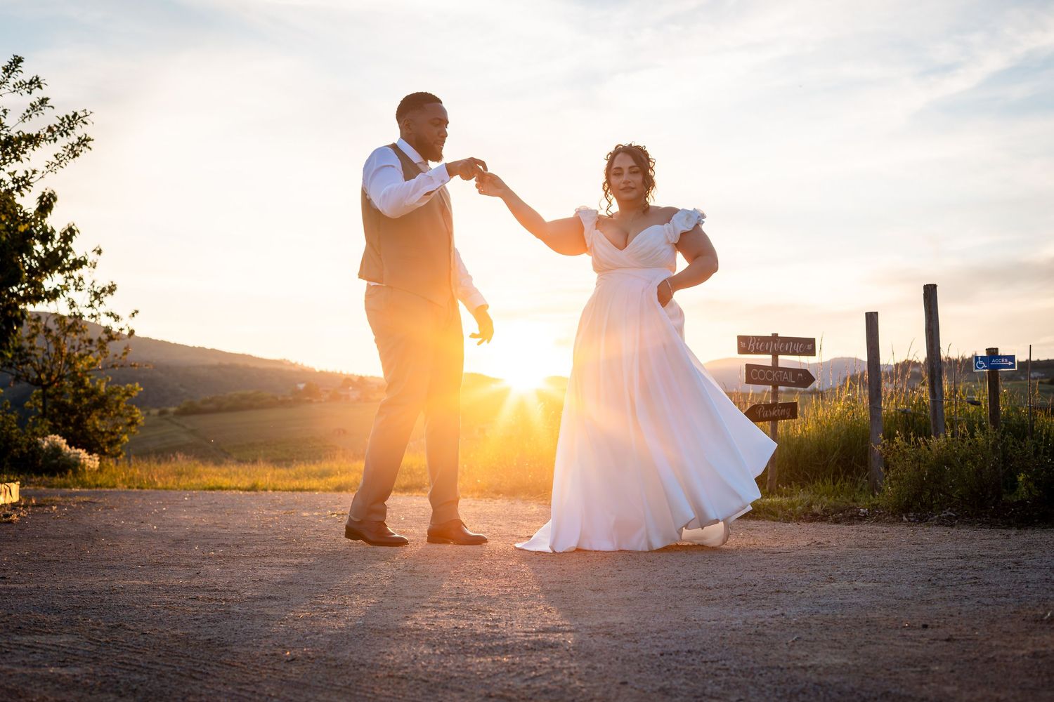 couple de mariés se tiennent la main au couché de soleil