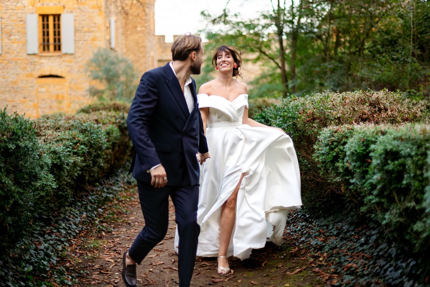 couple de mariés qui court main dans la main