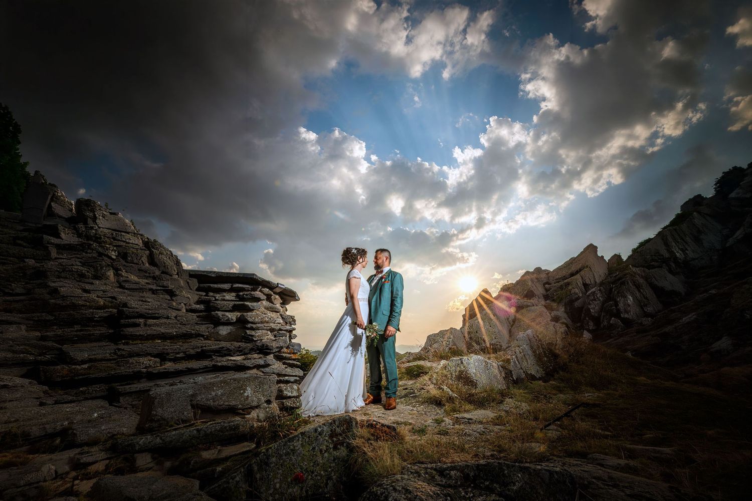 couple de mariés se tiennent la main au couché de soleil