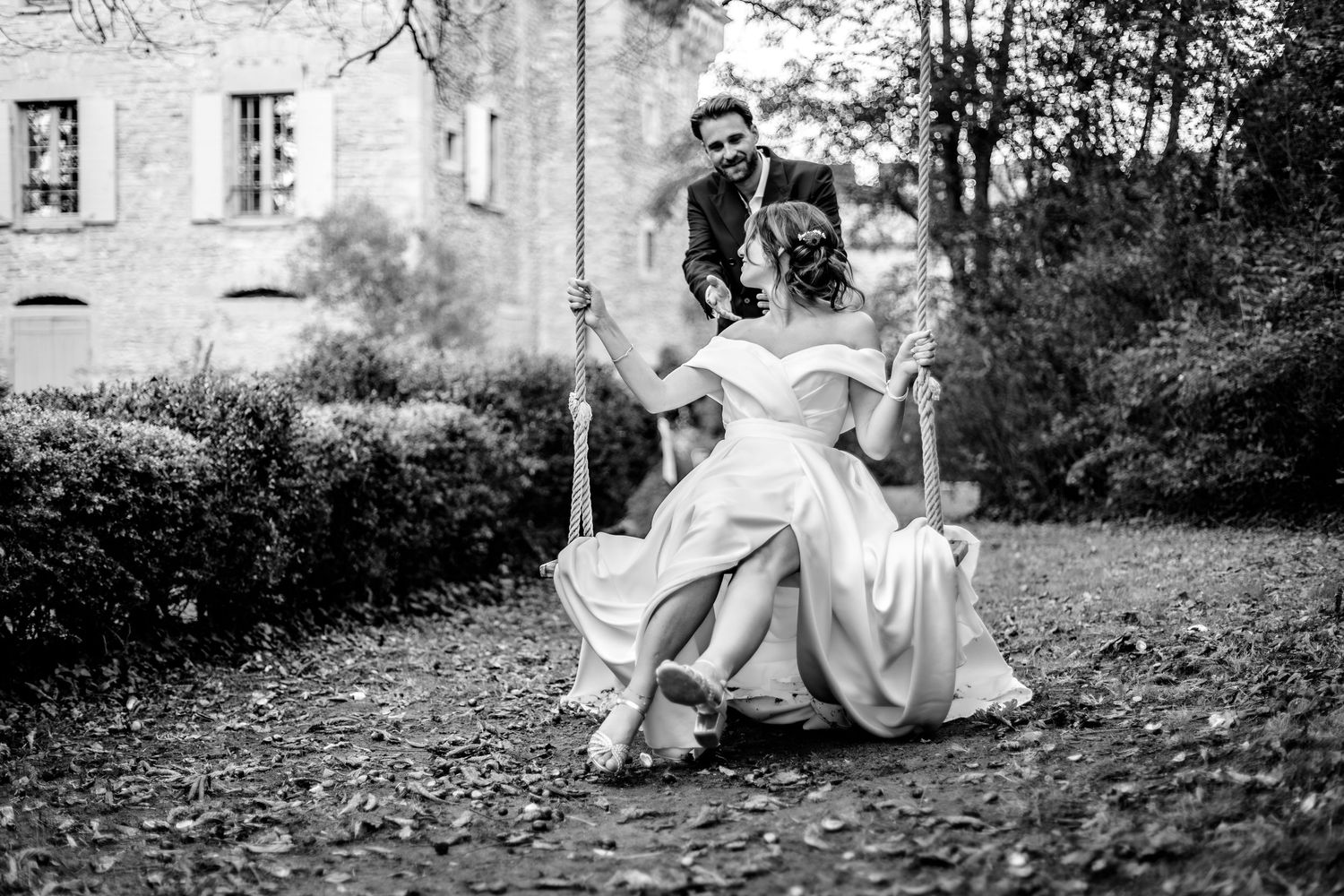 couple de mariés jouent à la balançoire