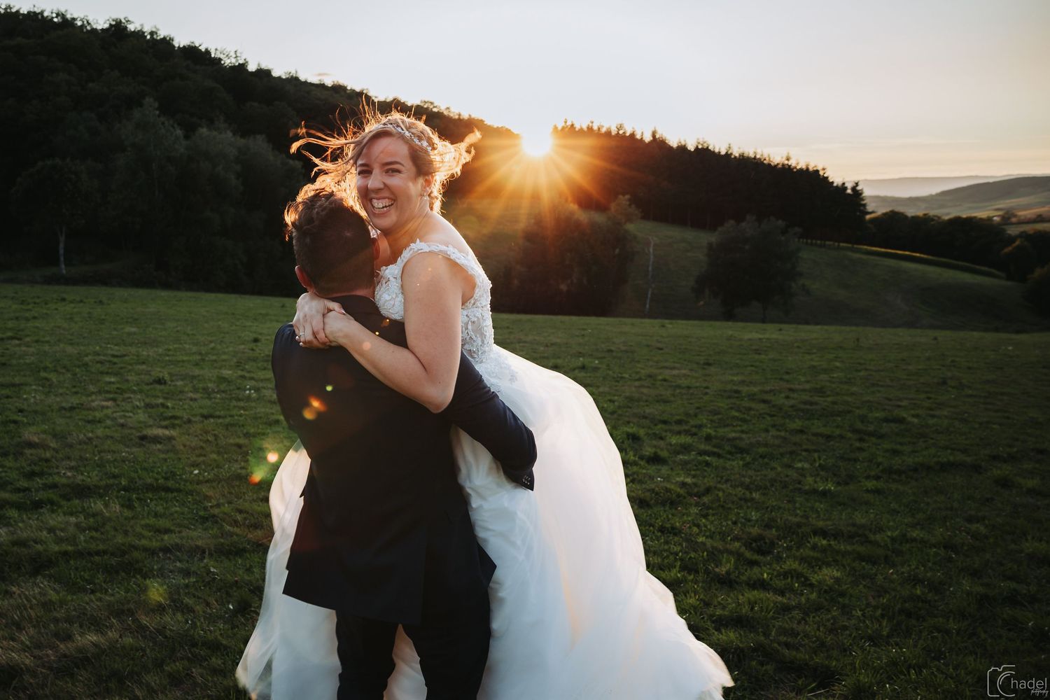 couple de mariés s'enlacent au couché de soleil