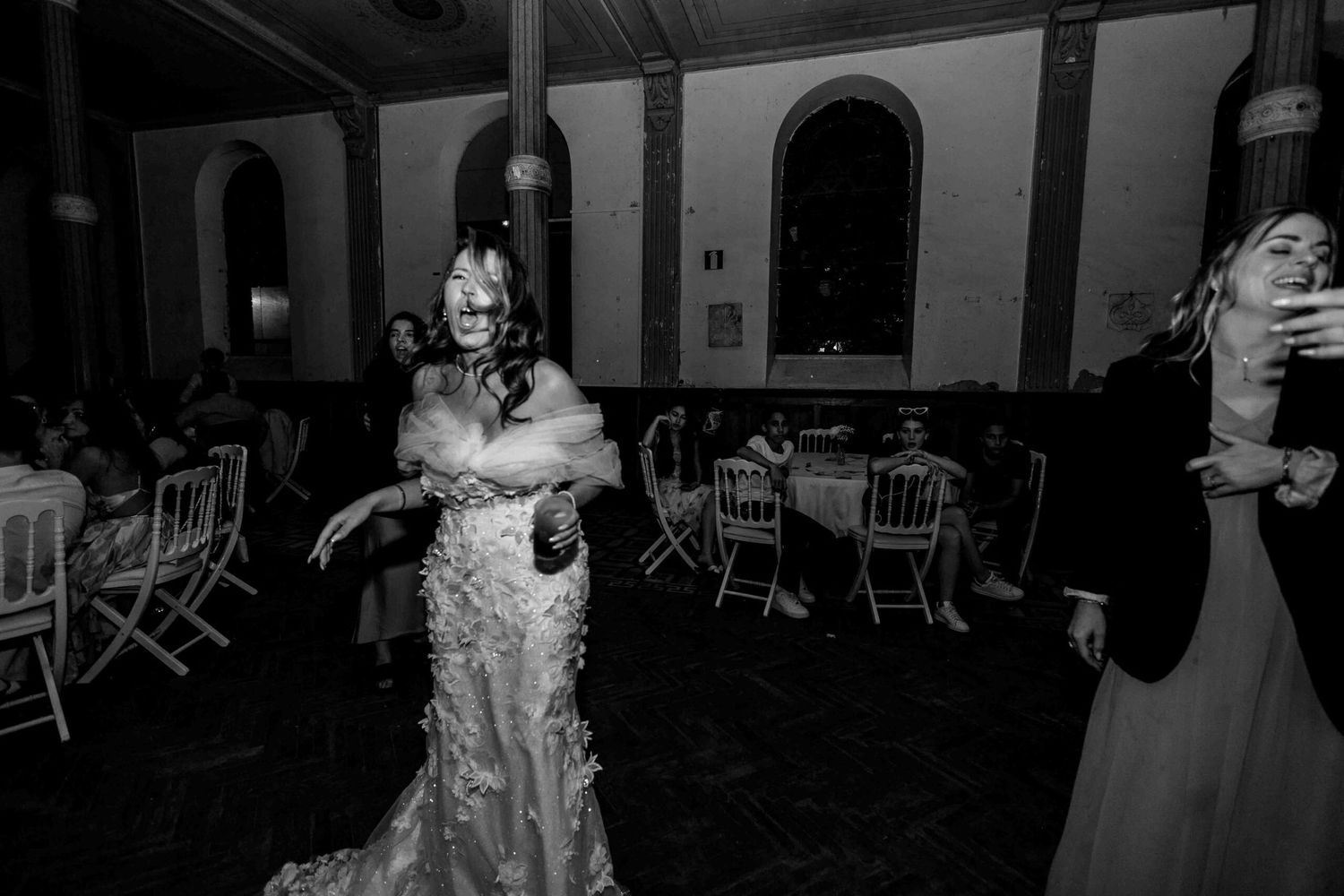 Wedding reception dance party in a dimly lit indoor venue.