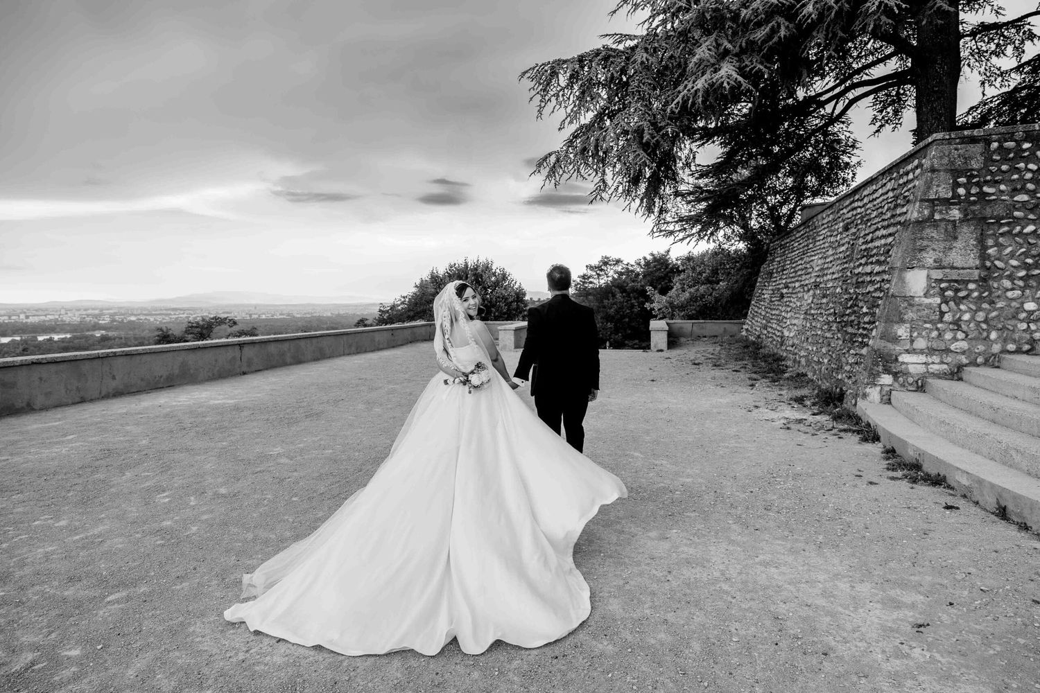 Dramatic wedding portraits taken against stone walls and scenic countryside views.
