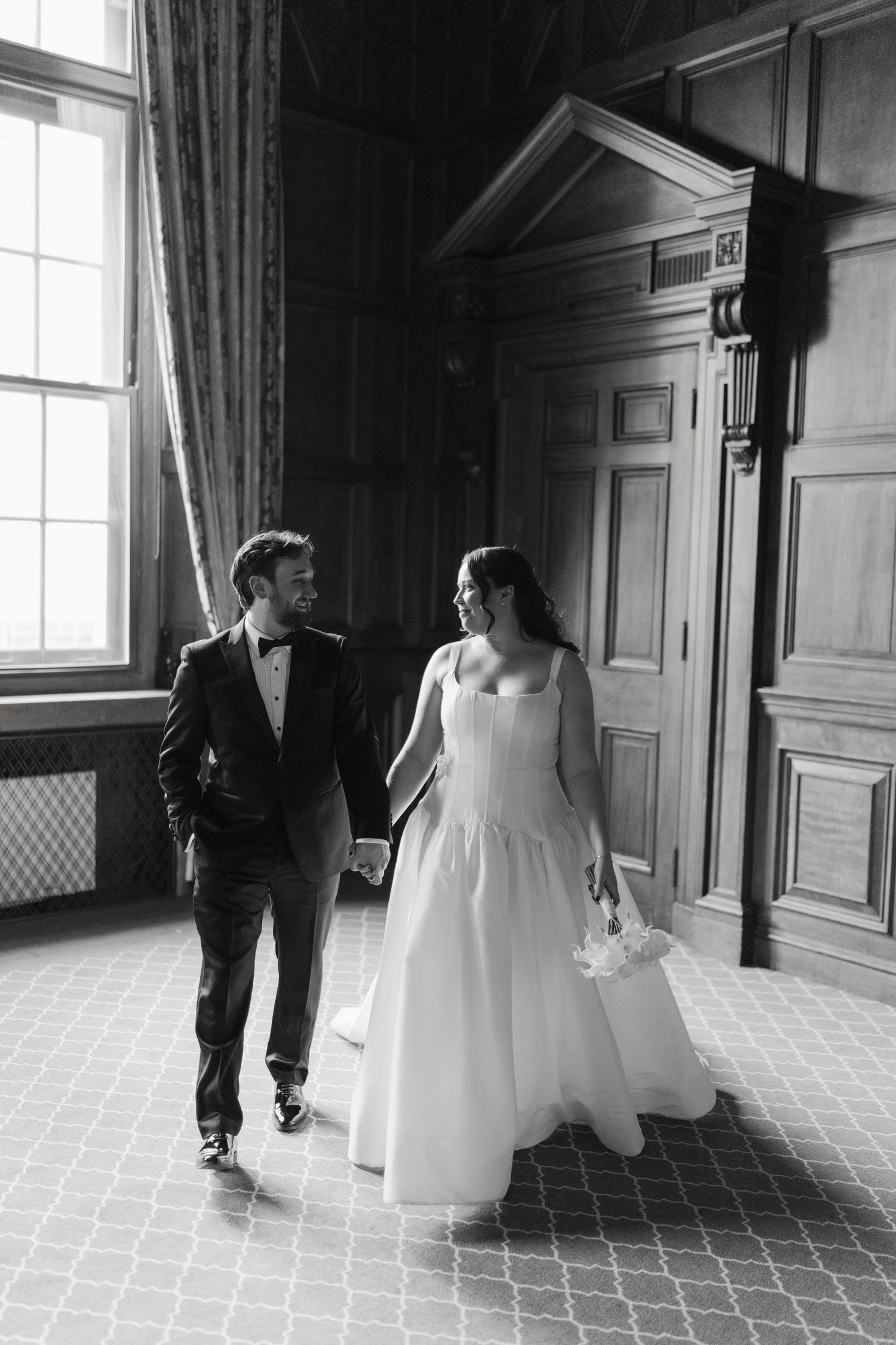Black and white sequence of wedding party walking through elegant hallway.