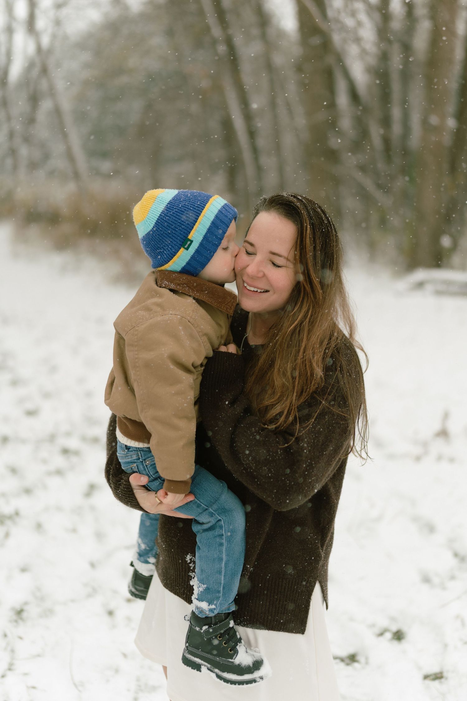 Playful winter scene with mother and child in snowy landscape.