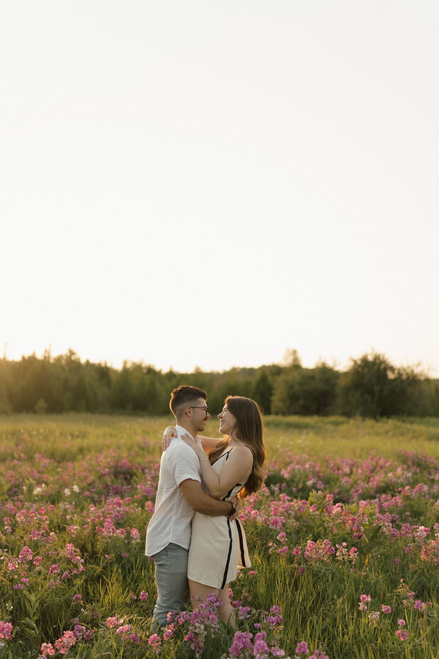 Romantic photoshoot in blooming wildflower field during sunset.