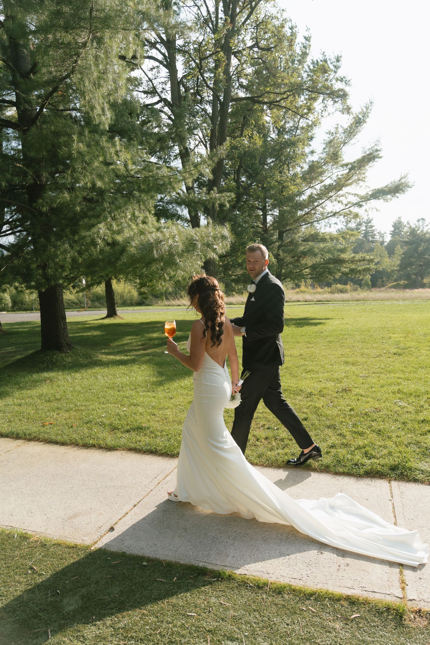 A couple enjoying a candid moment on their wedding day with flowing dress train.