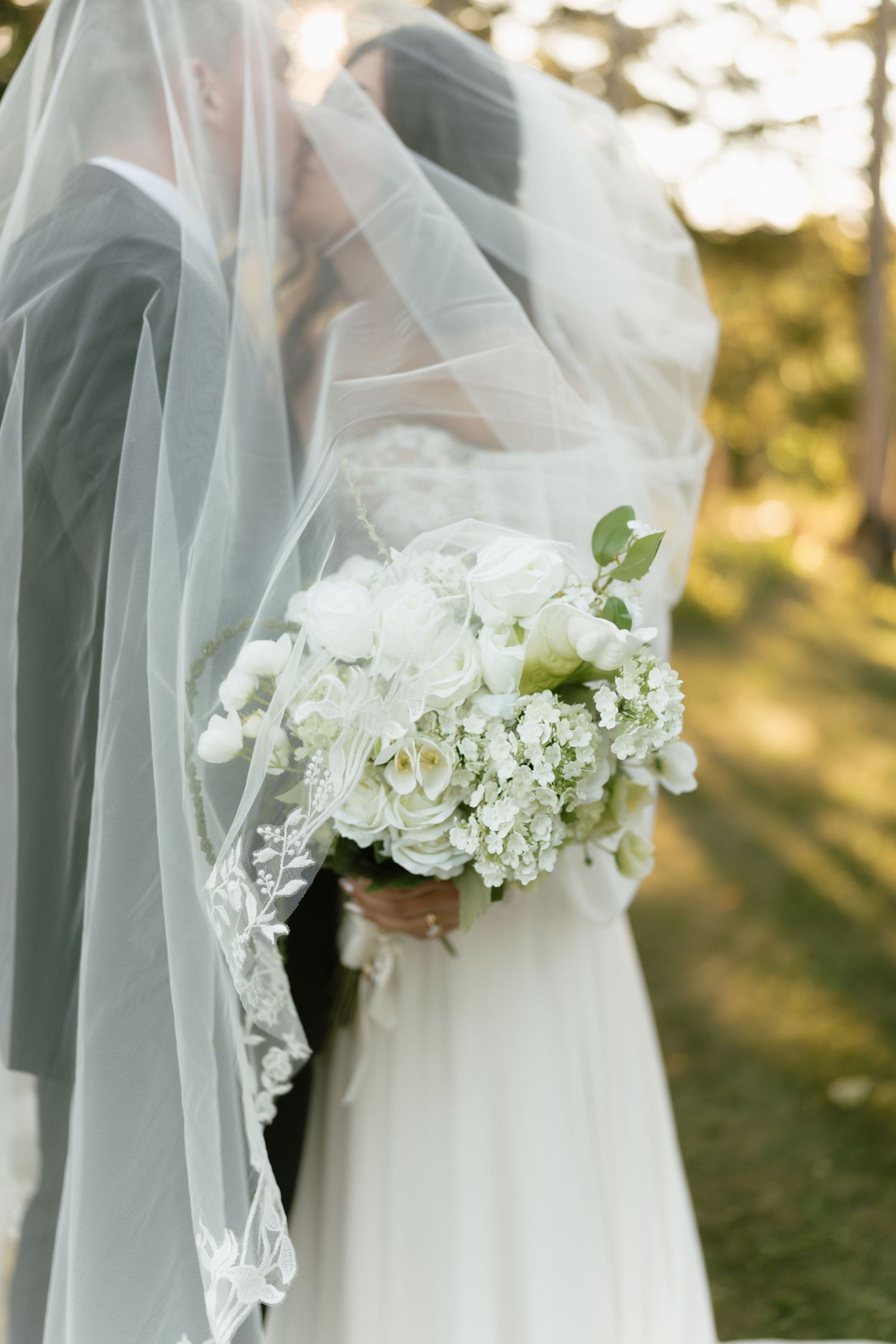 Close-up details of a white wedding veil with delicate floral embellishments.