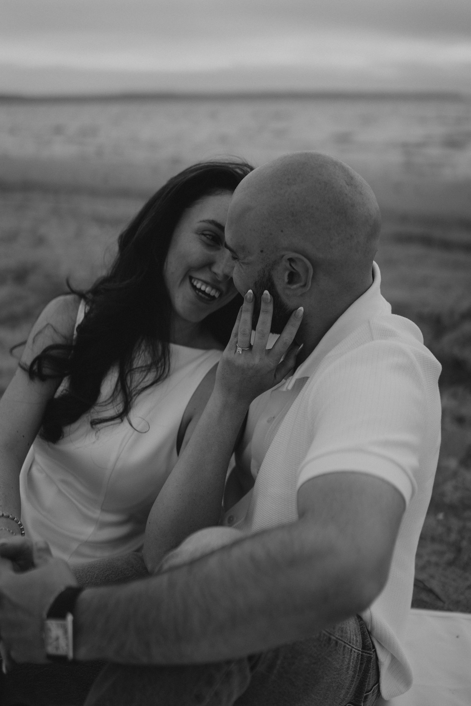 Couple sharing intimate moment while lying down outdoors.