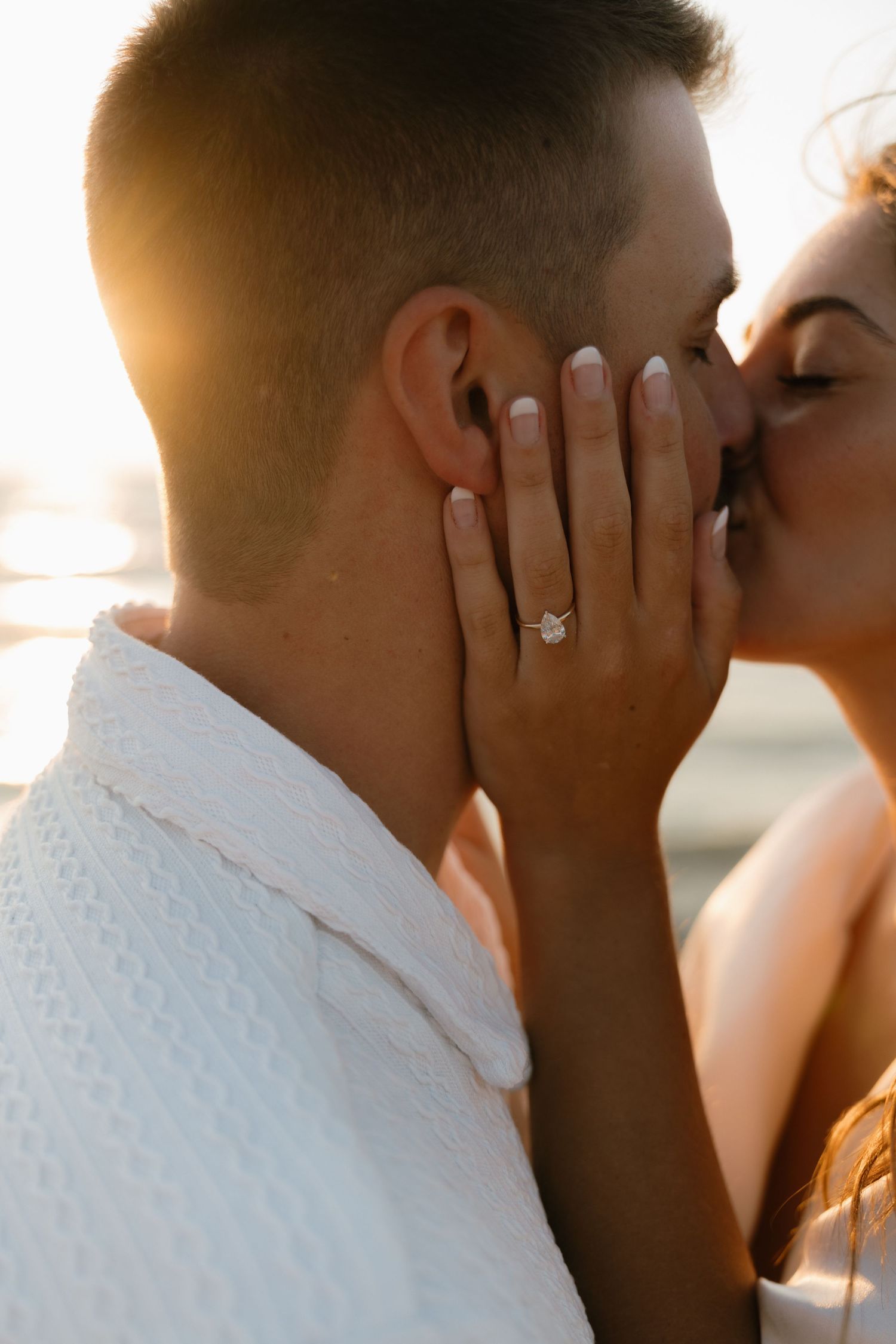 Close-up romantic moment captured during sunset beach photoshoot.