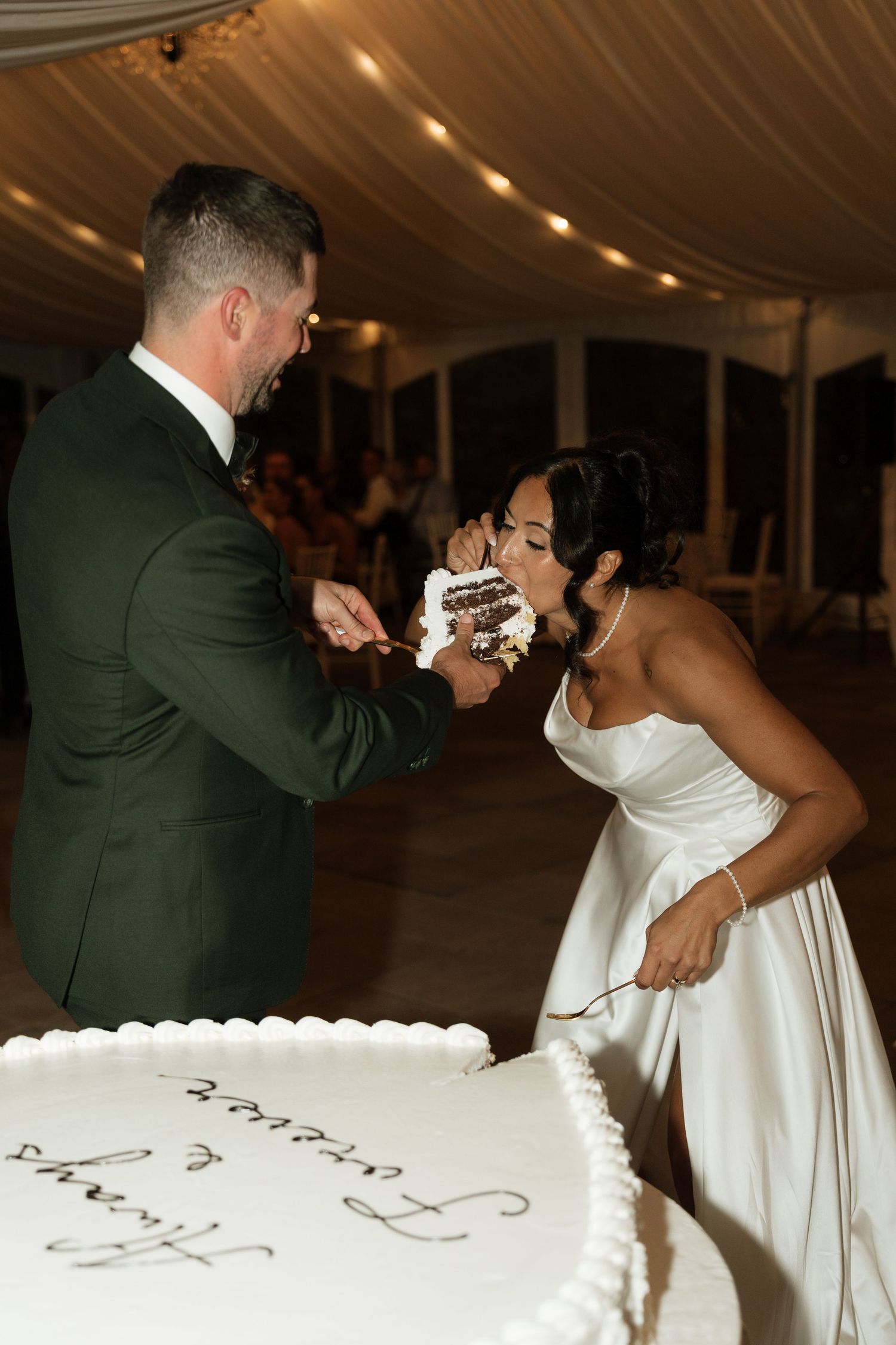 A playful cake-cutting moment at a wedding reception.