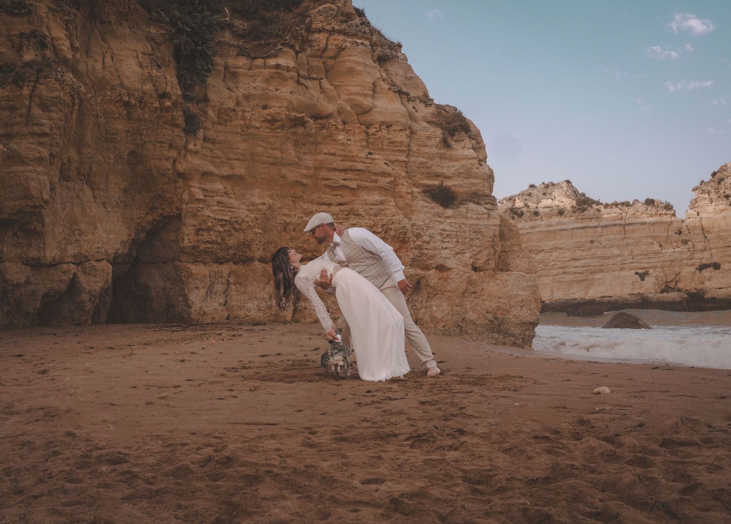Romantic wedding portrait of a newlywed couple on the cliffs of Praia Dona Ana, Lagos, Portugal