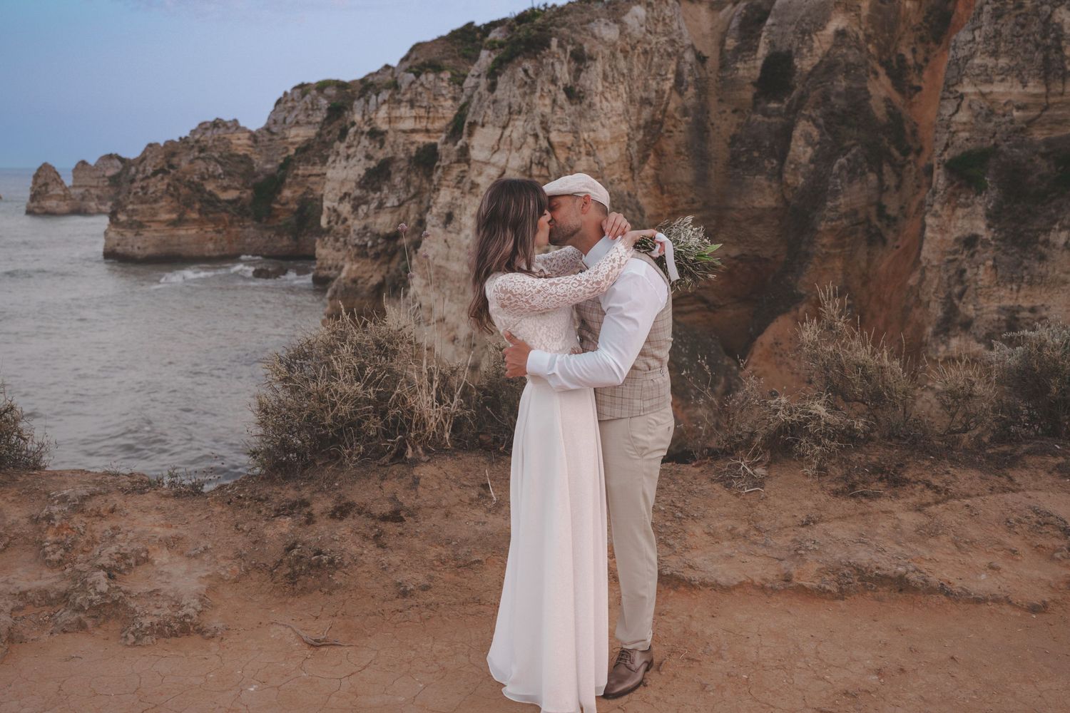 Newly married couple celebrating on Praia Dona Ana beach during a destination wedding in the Algarve