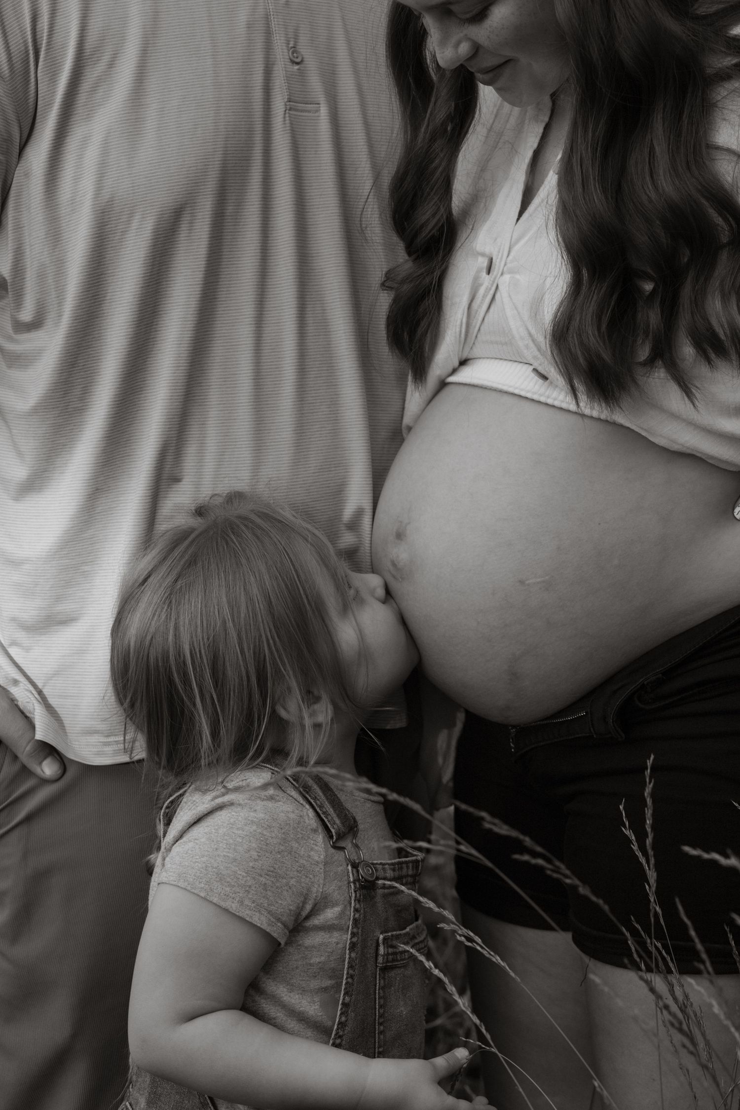 Black and white intimate maternity photo session showing tender family moments.