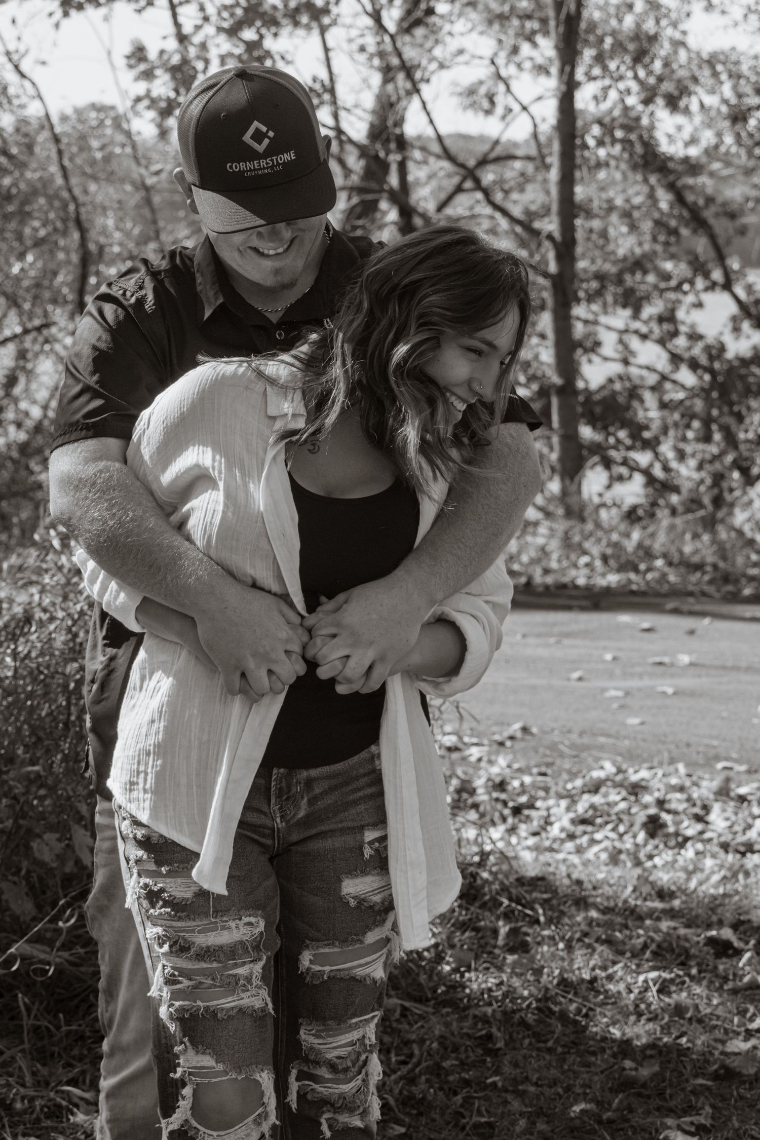 A couple sharing an intimate embrace in black and white photography outdoors.