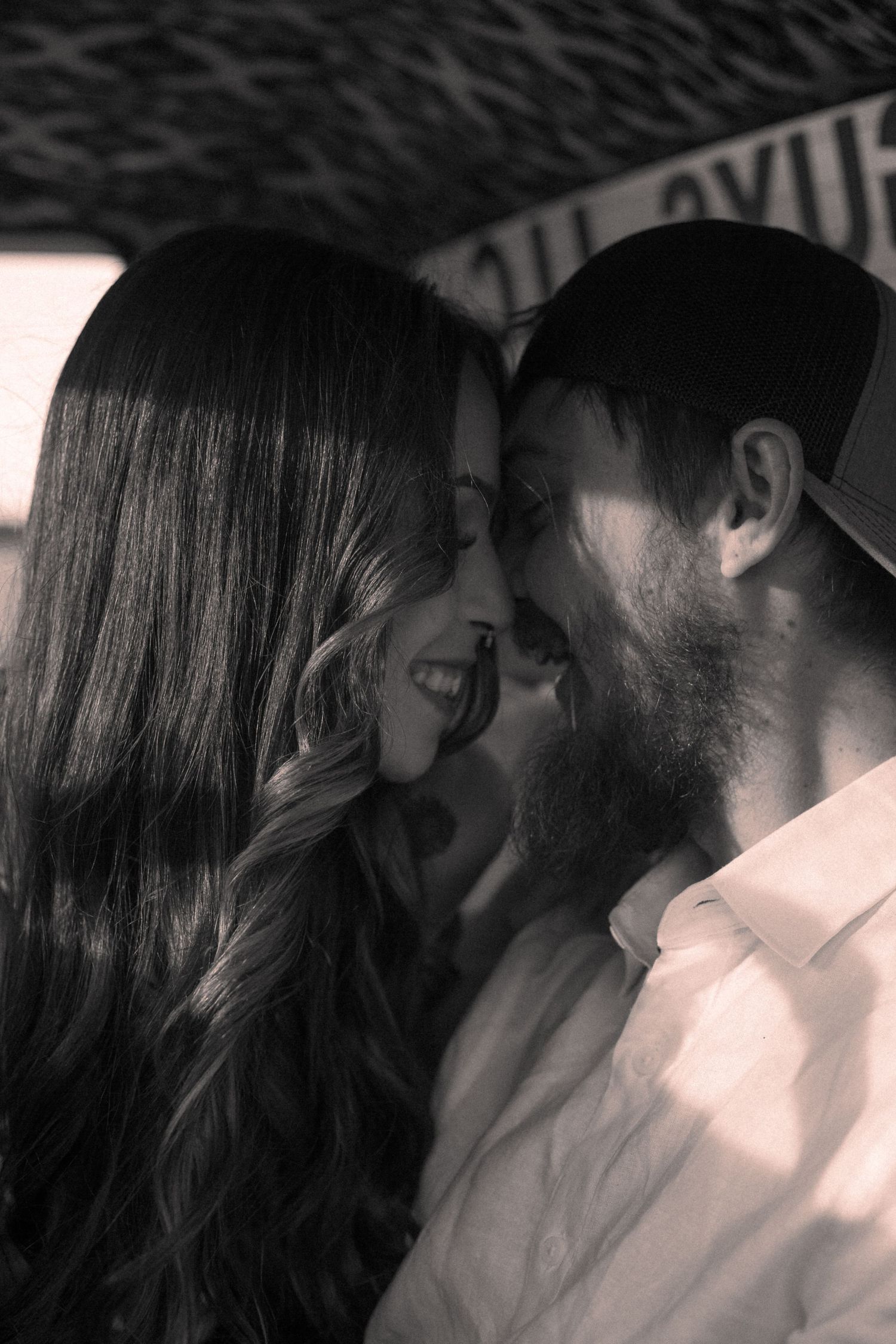 Intimate black and white portrait of a couple sharing a close moment.