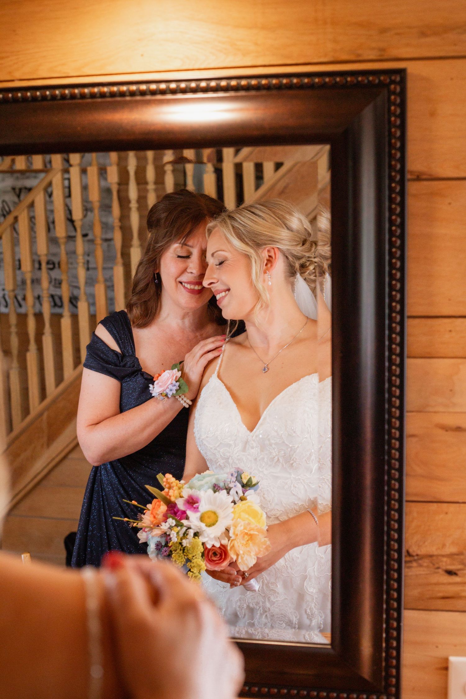 Emotional wedding preparation moment captured in mirror reflection with colorful bouquet.
