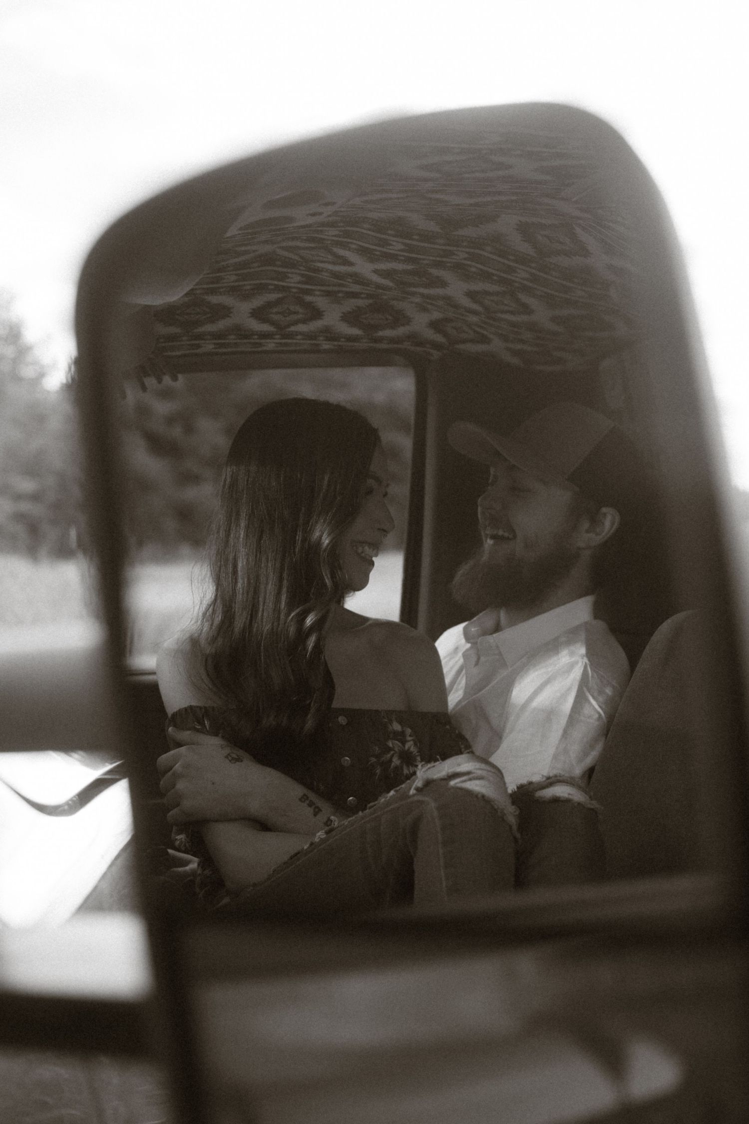 Romantic vintage-style photo captured through a car window showing a tender moment.