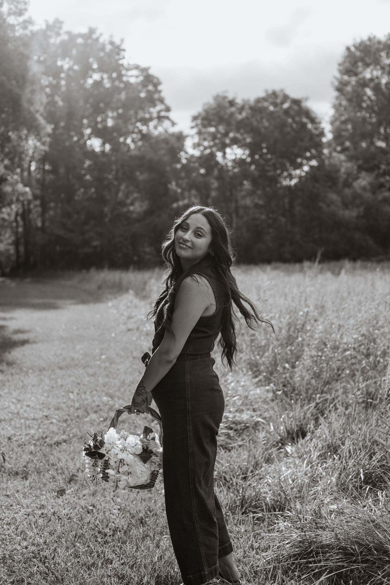 Black and white portrait in a serene meadow setting.