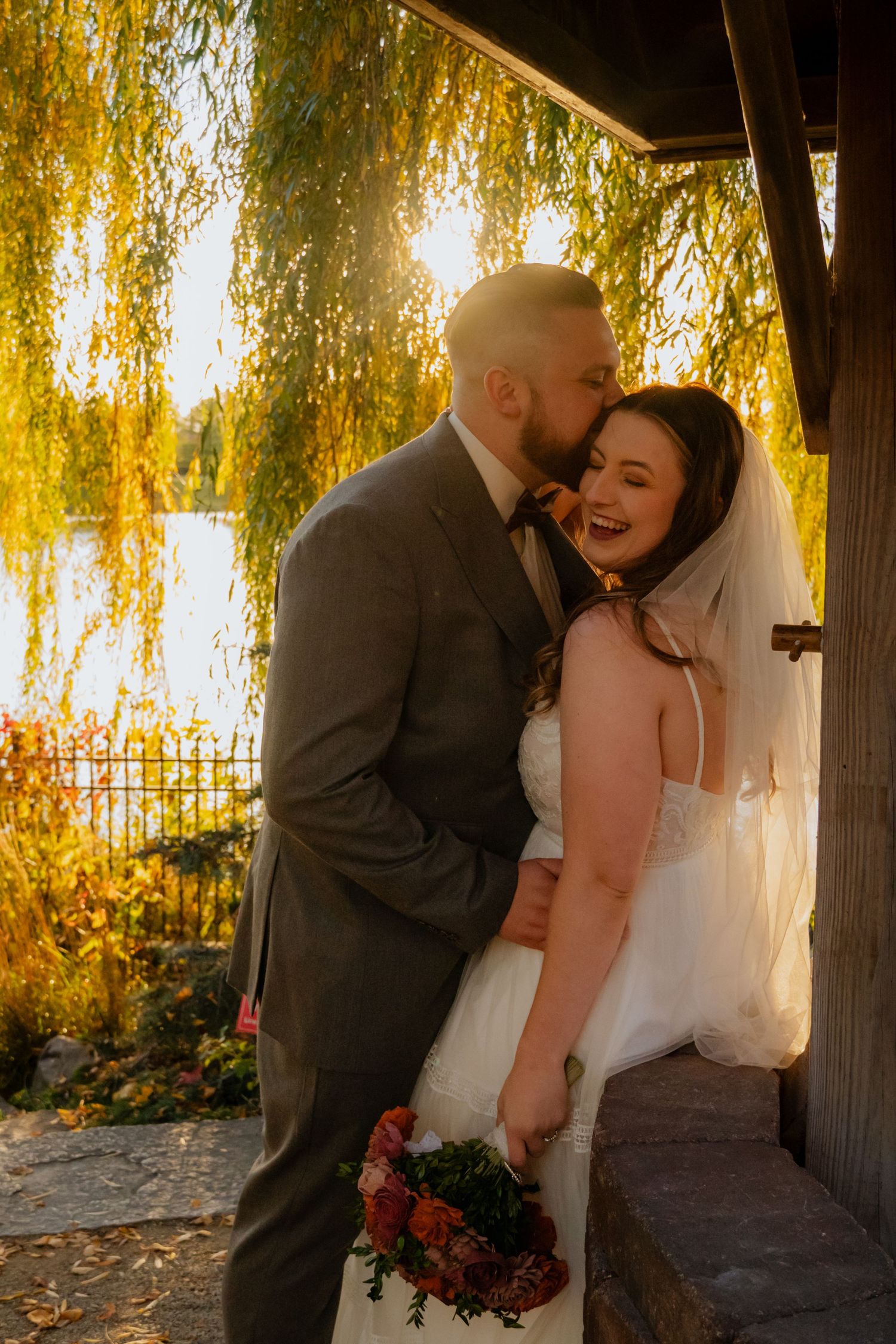 Sunset wedding portraits captured under golden willow trees.
