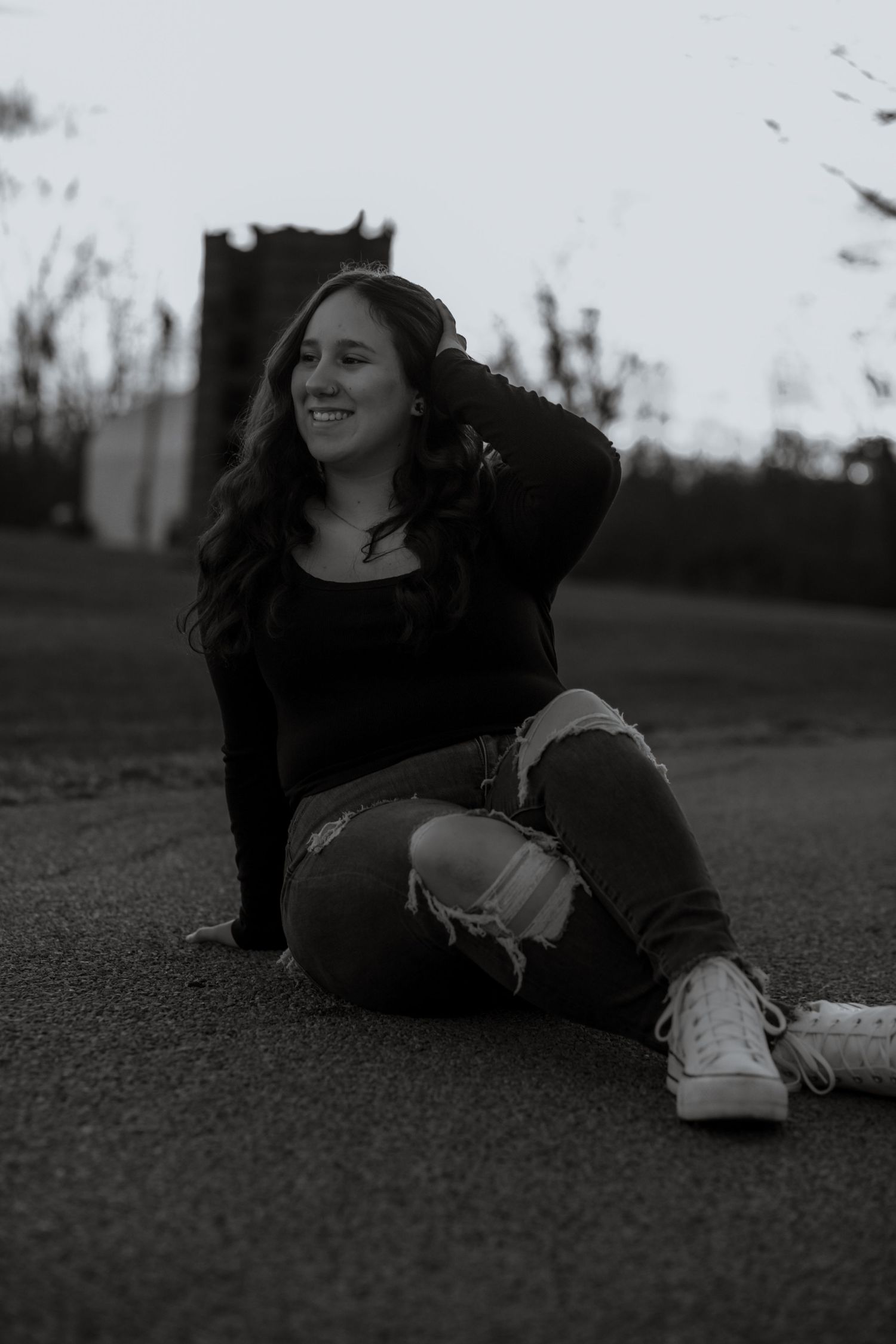 Artistic black and white photos taken from ground level on an asphalt surface at dusk.
