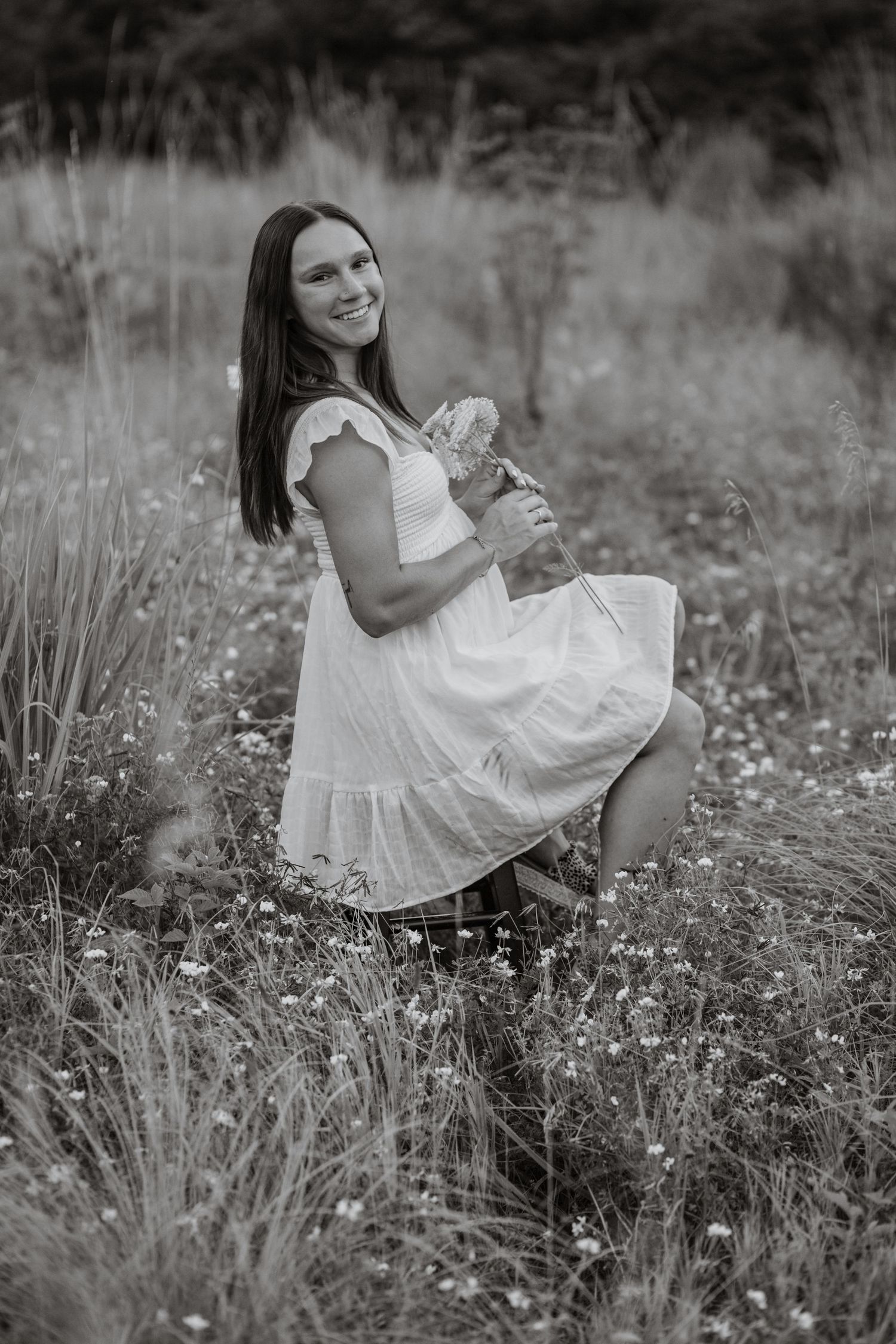 Artistic black and white photos of someone in a white dress among wildflowers.