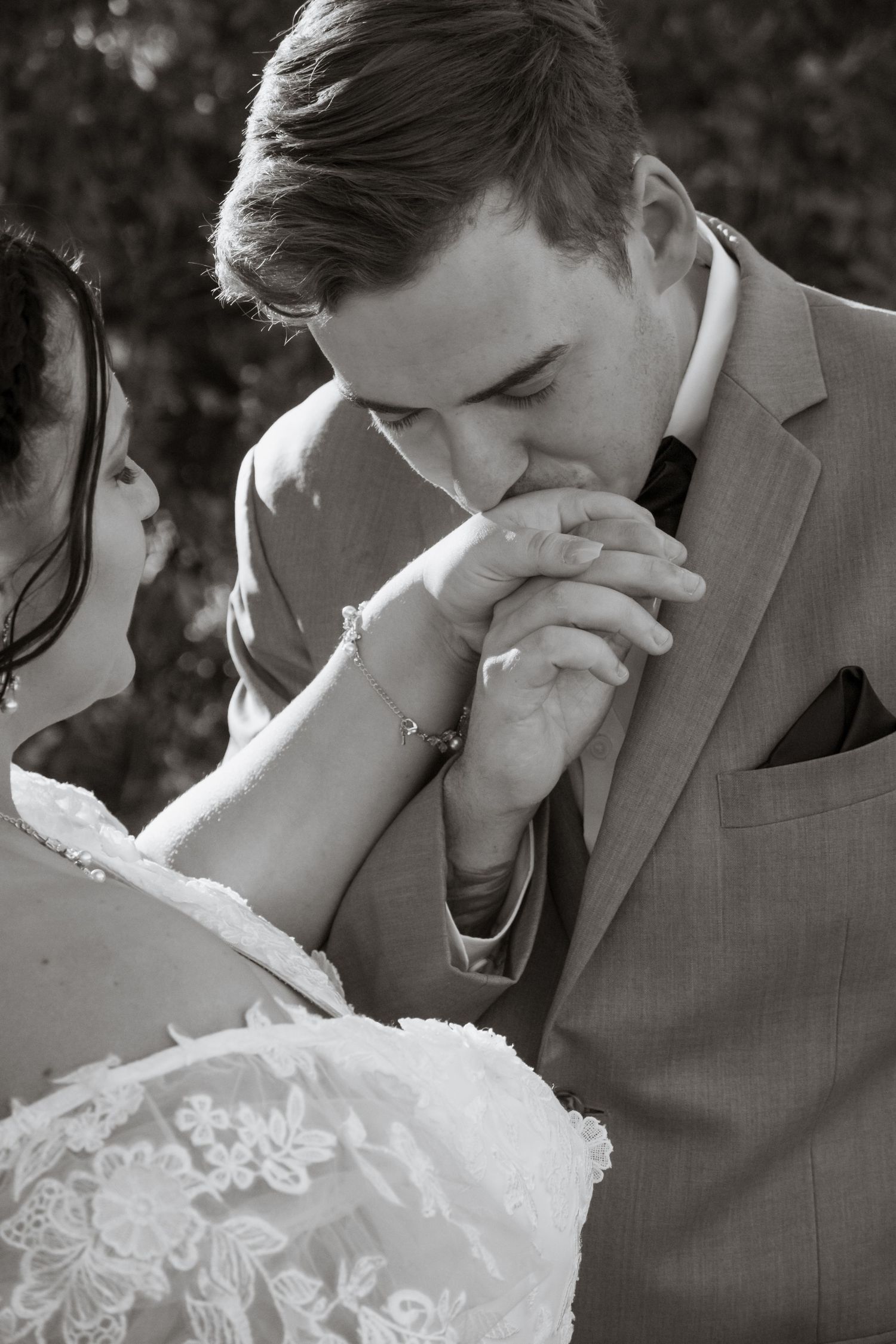 Romantic black and white photo of couple sharing an intimate moment in formal attire.