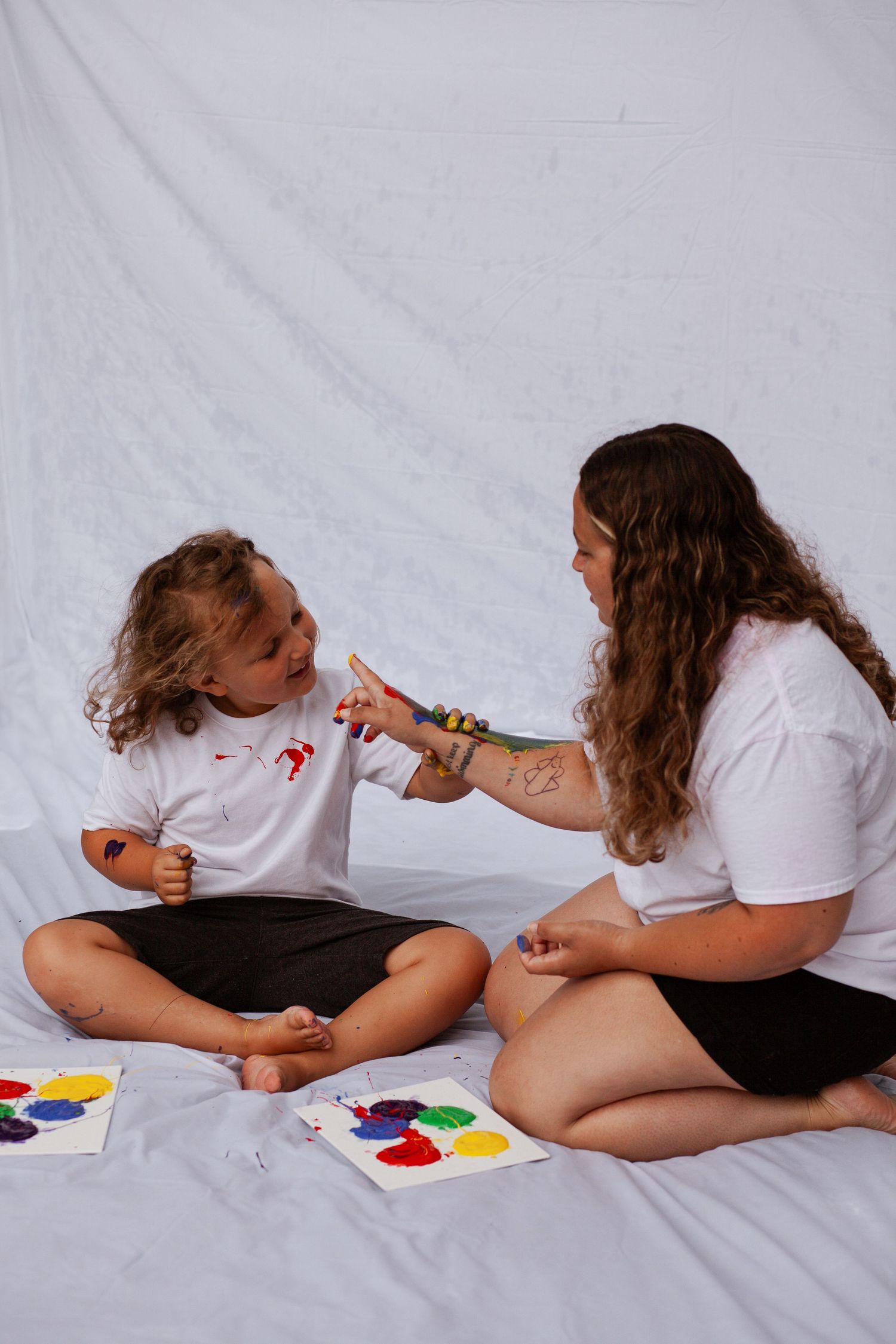 Creative maternity painting session on white background.