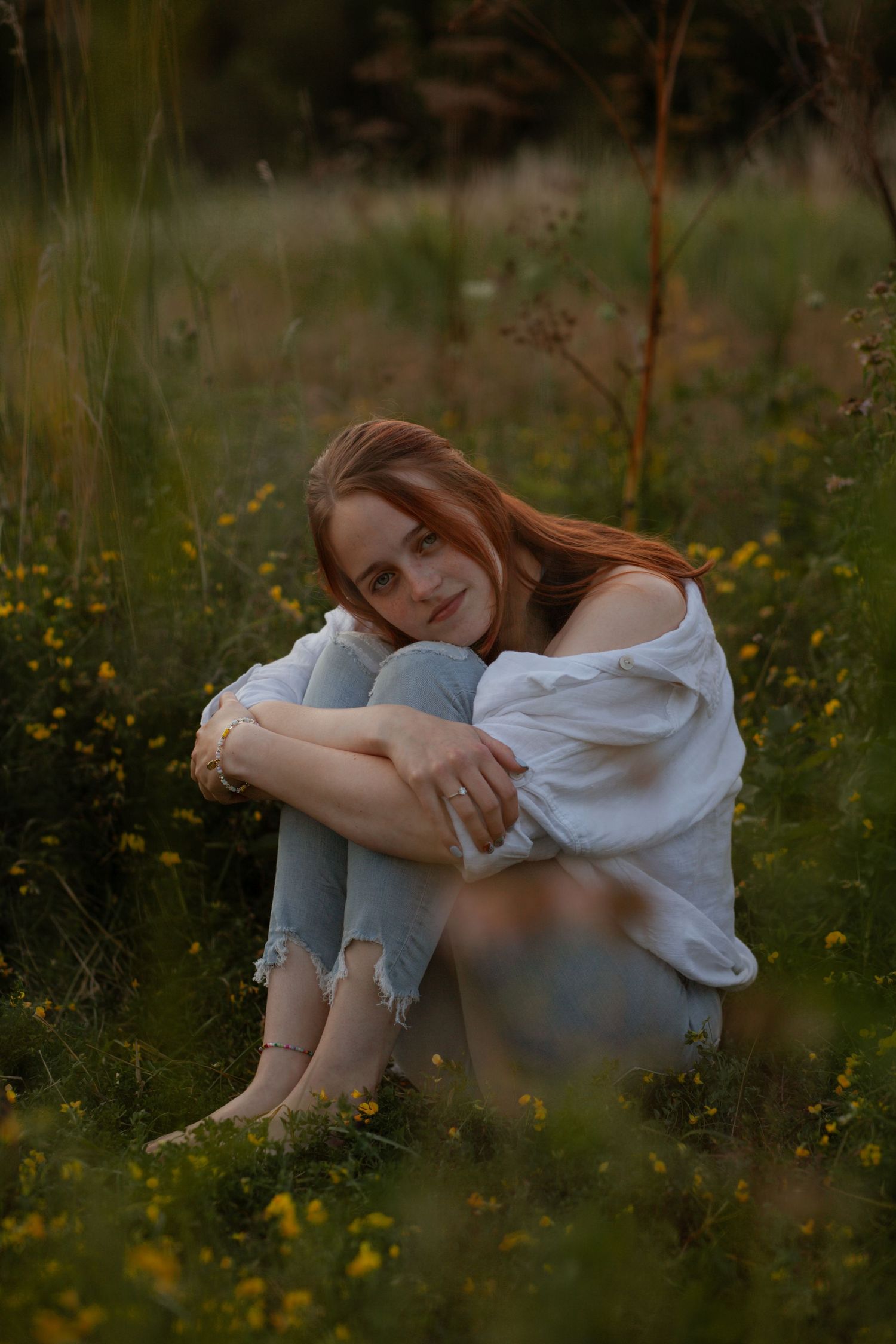 Dreamy portrait in a wildflower meadow at dusk wearing white and denim.