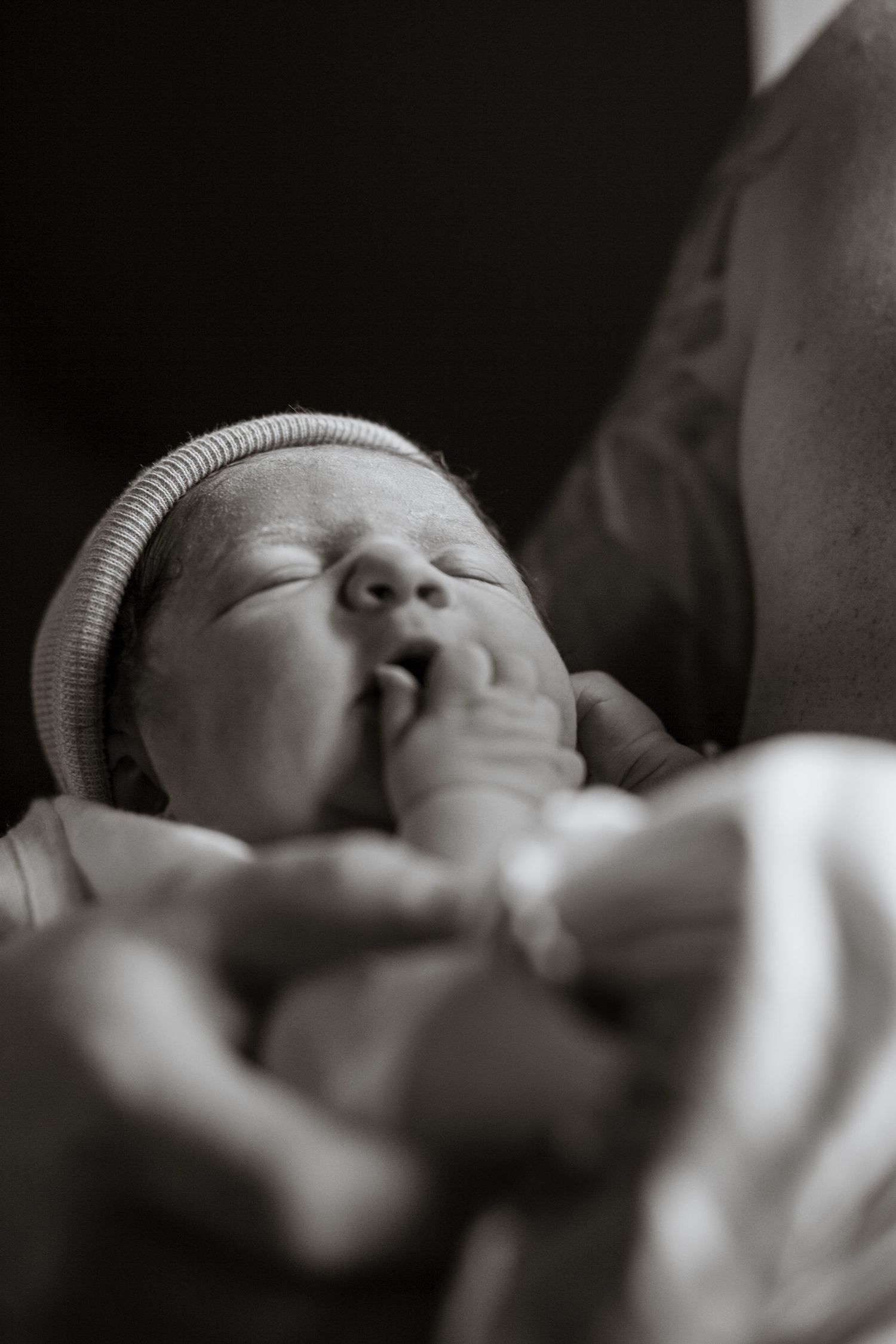 Close-up black and white sequence of peaceful newborn wearing knit cap.