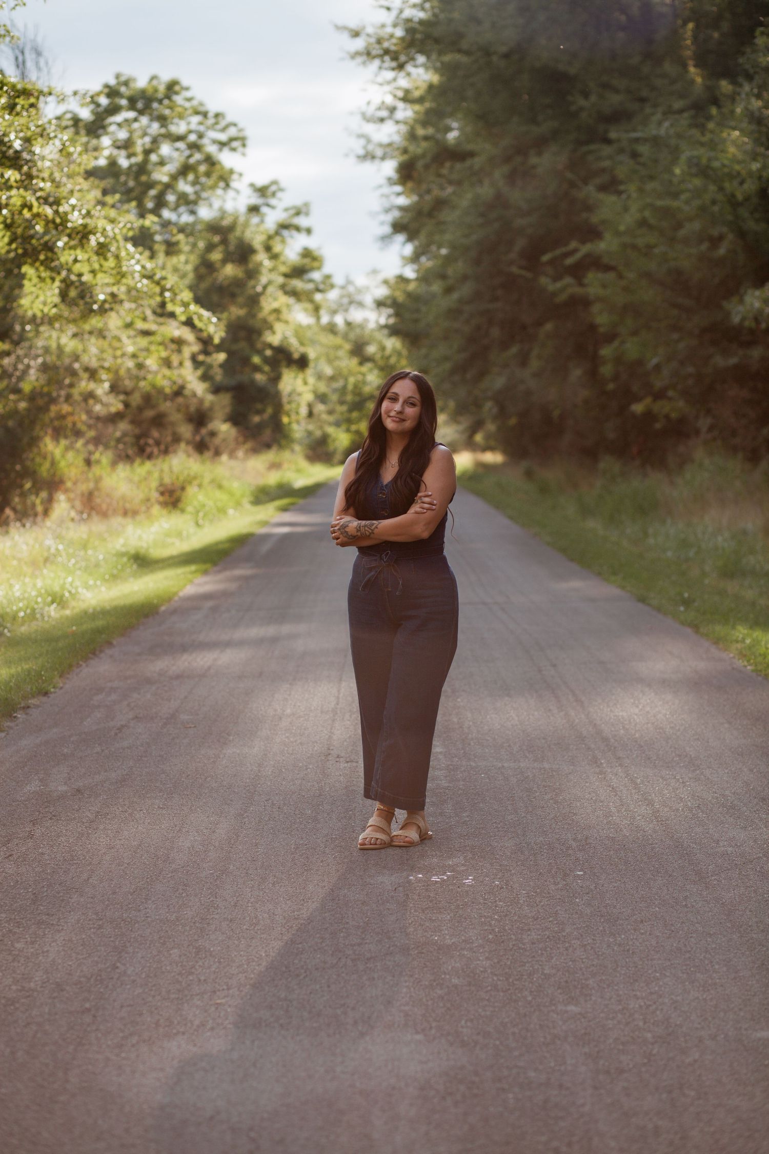 Artistic portrait on a country road surrounded by trees.