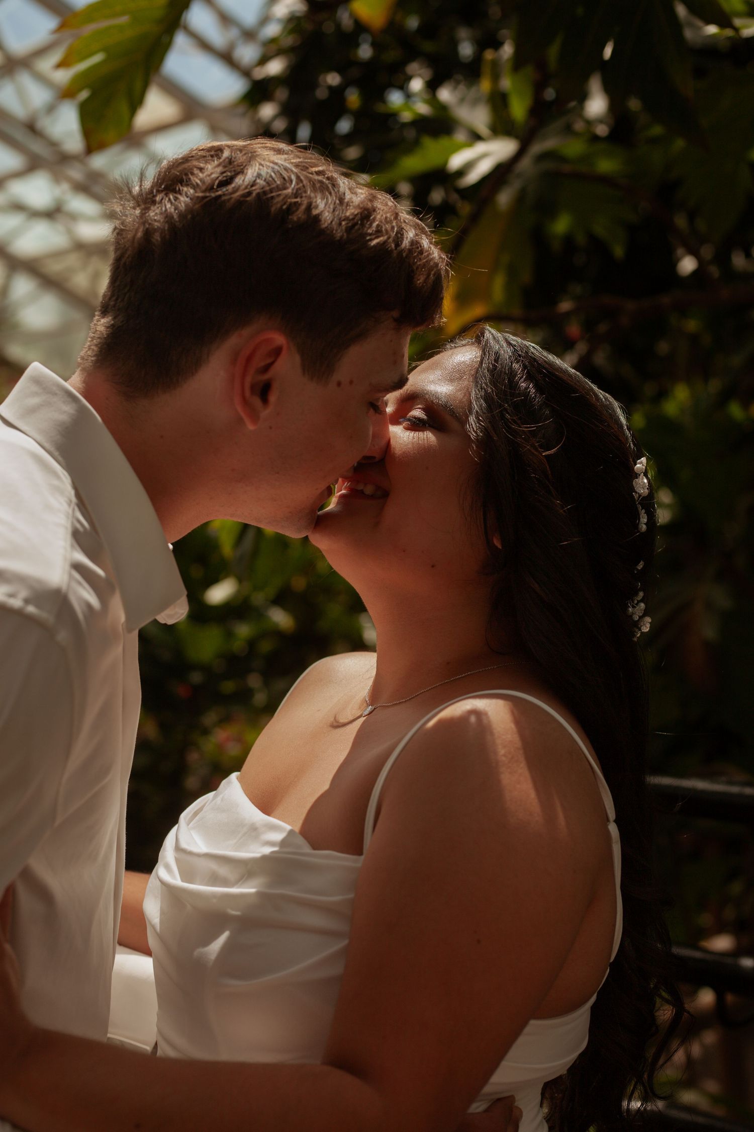 Intimate wedding portrait with couple sharing romantic moment in natural lighting.