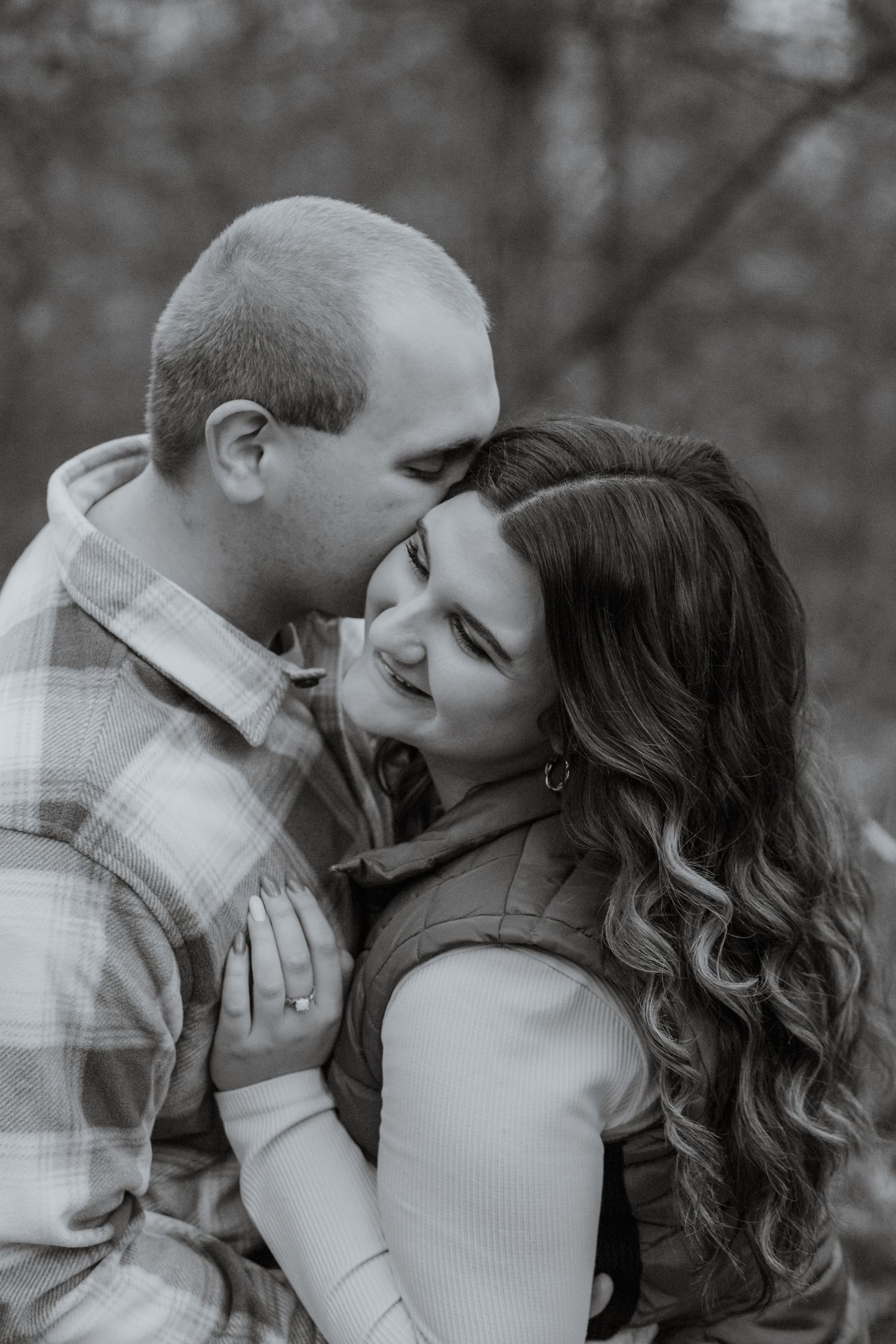 An affectionate couple embracing and sharing a tender moment in black and white photography.