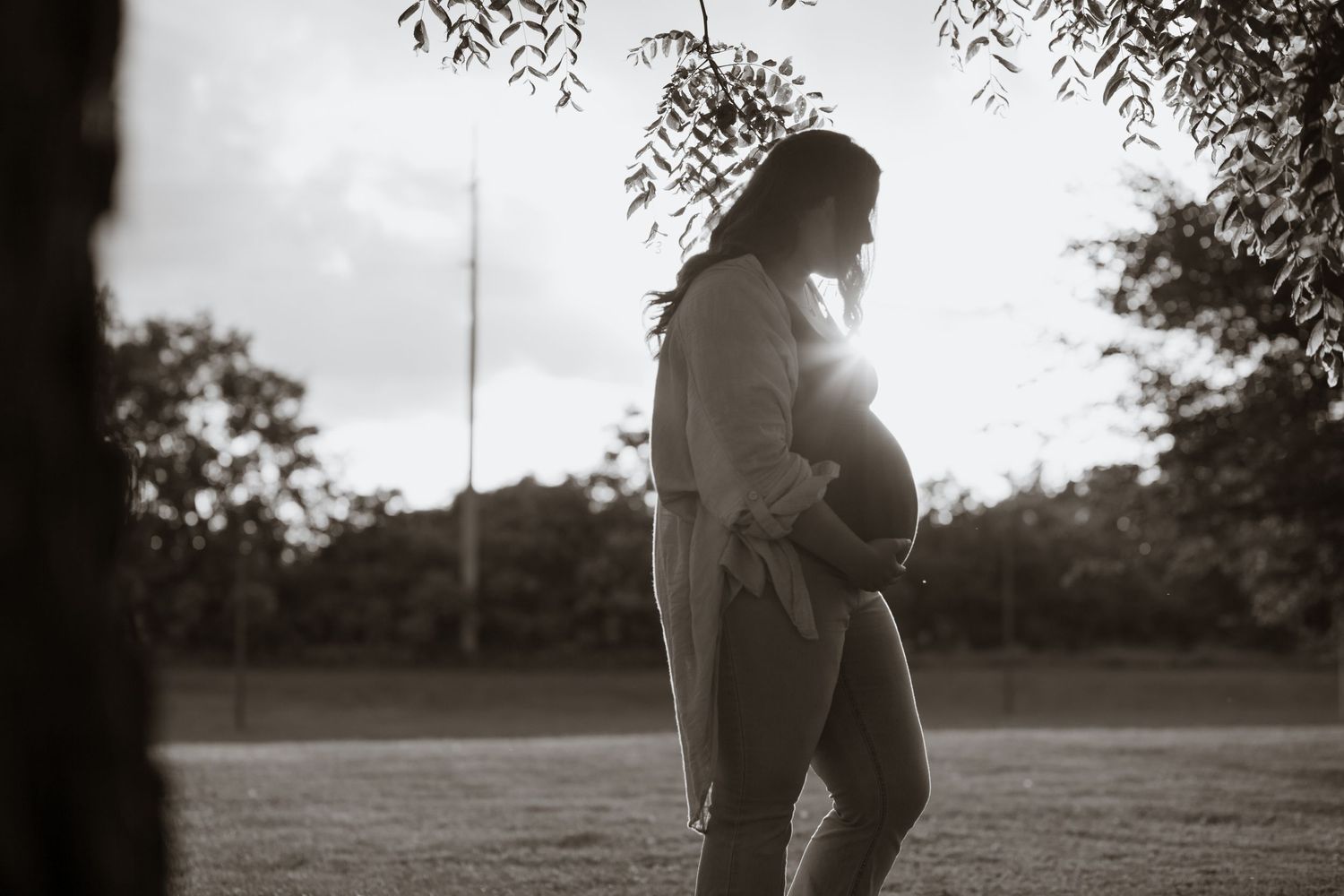 A silhouetted couple embracing during sunset in a romantic black and white photo sequence.