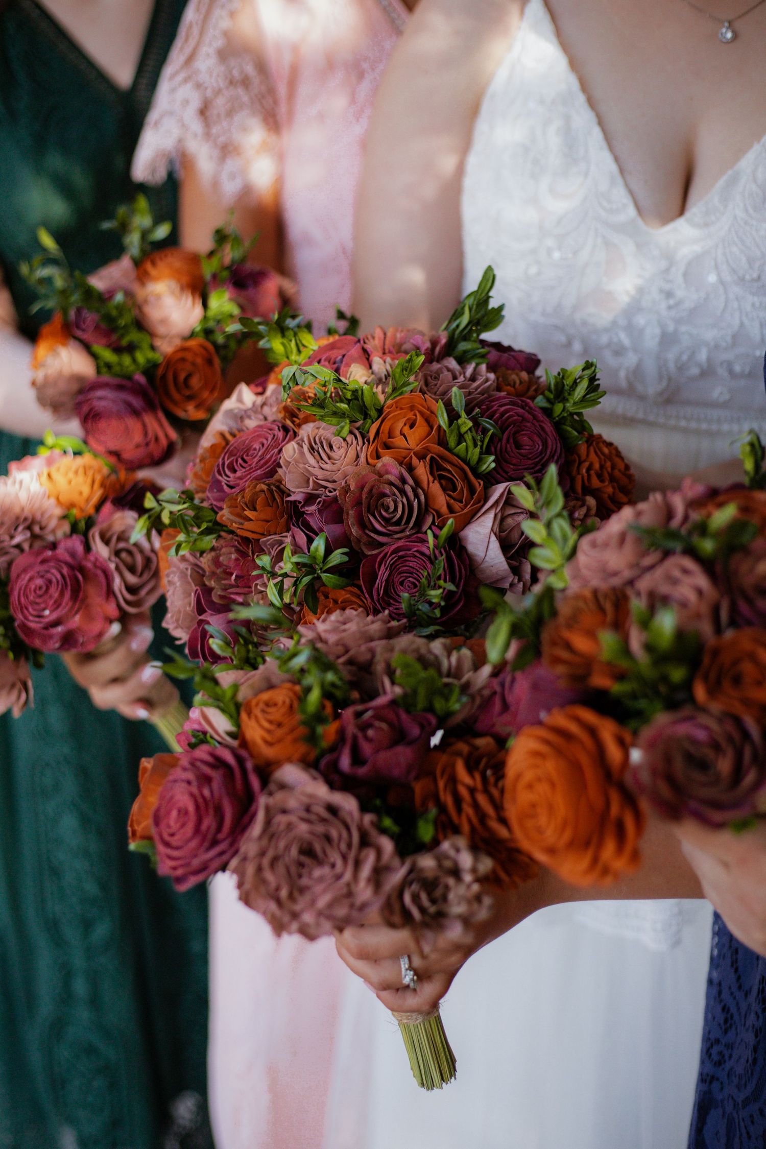 Rich autumn-colored wedding bouquet with deep red and orange roses.
