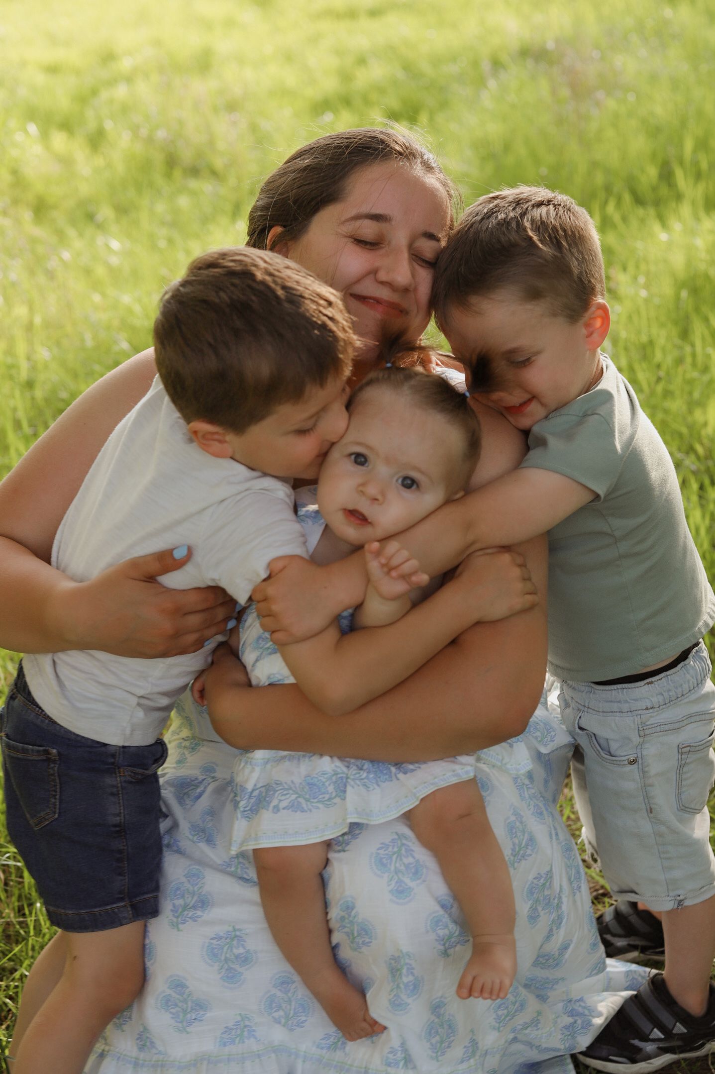 Joyful family photo sequence showing group hugs in a sunny grassy field.