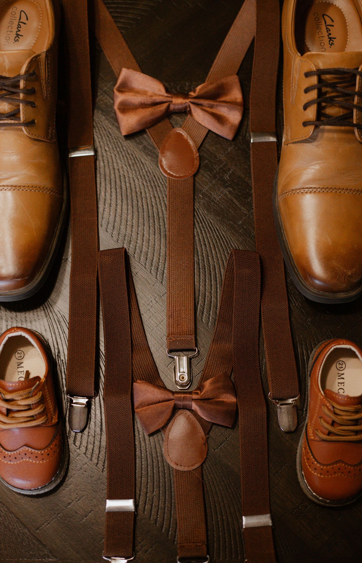 Brown leather dress shoes and bow ties arranged for wedding detail photography.